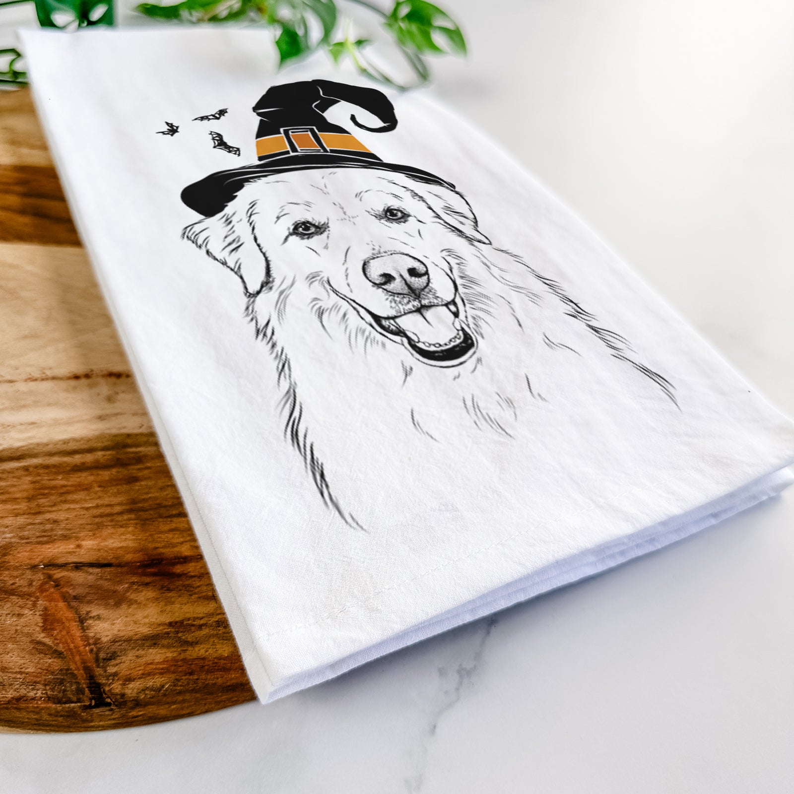 Hand-drawn sketch of Meg the Great Pyrenees wearing a witch hat on a tea towel