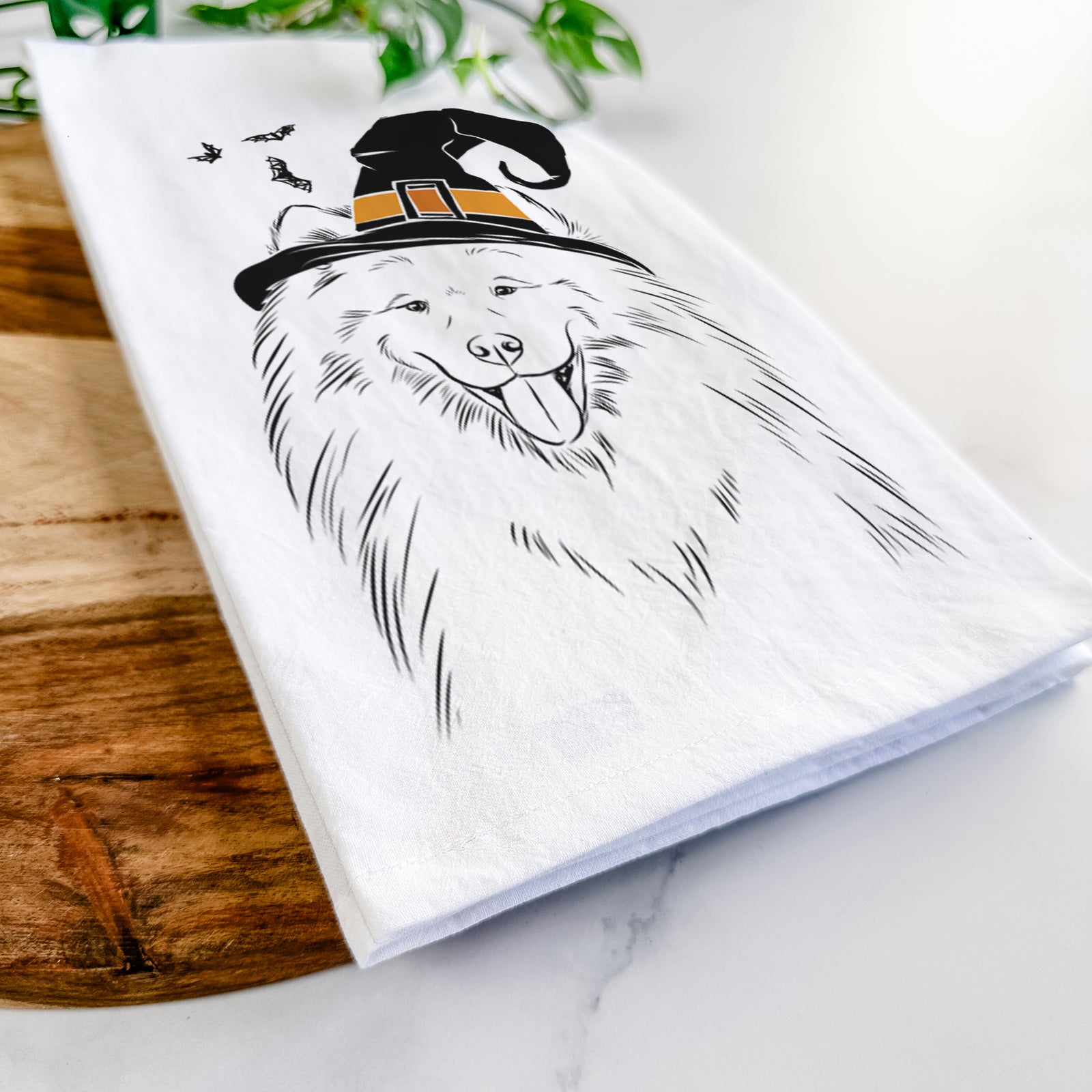 Hand-drawn sketch of Mikko the Samoyed wearing a witch hat on a tea towel