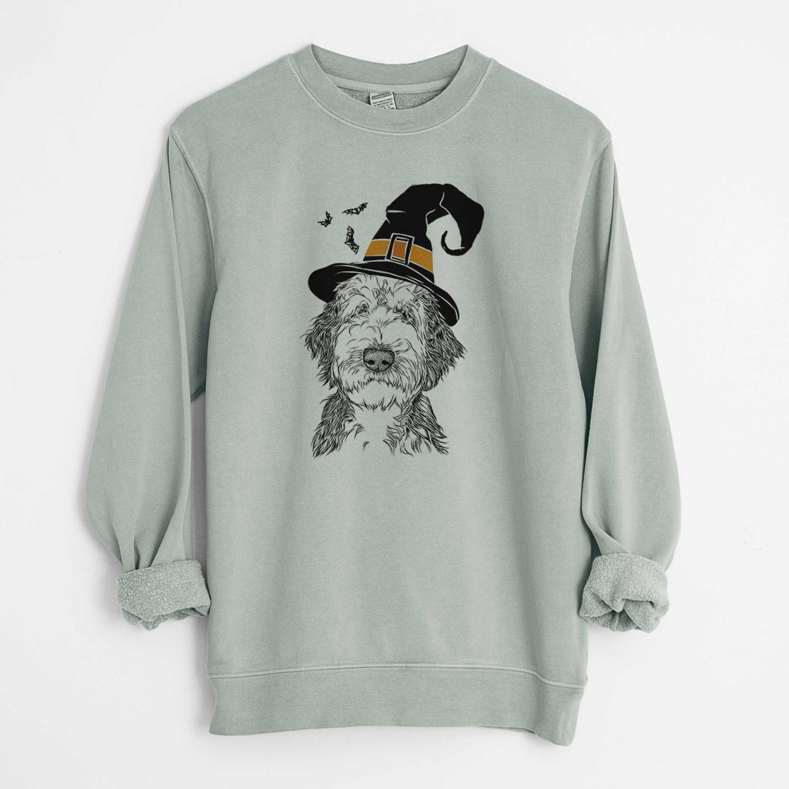 Hand-drawn sketch of Milo Fluff the Sheepadoodle wearing a witch hat on a Sage Unisex pigment dyed crew sweatshirt
