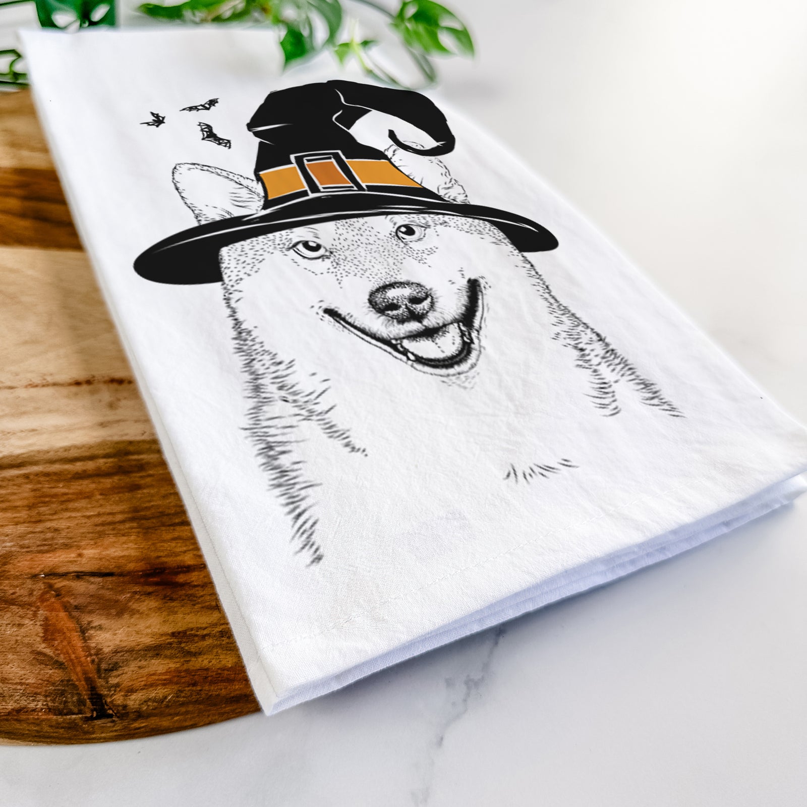 Hand-drawn sketch of Mitsu the Shiba Inu wearing a witch hat on a tea towel
