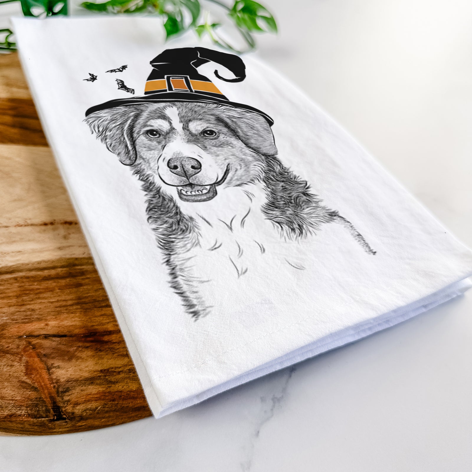 Hand-drawn sketch of Molly the Miniature Bernedoodle wearing a witch hat on a tea towel
