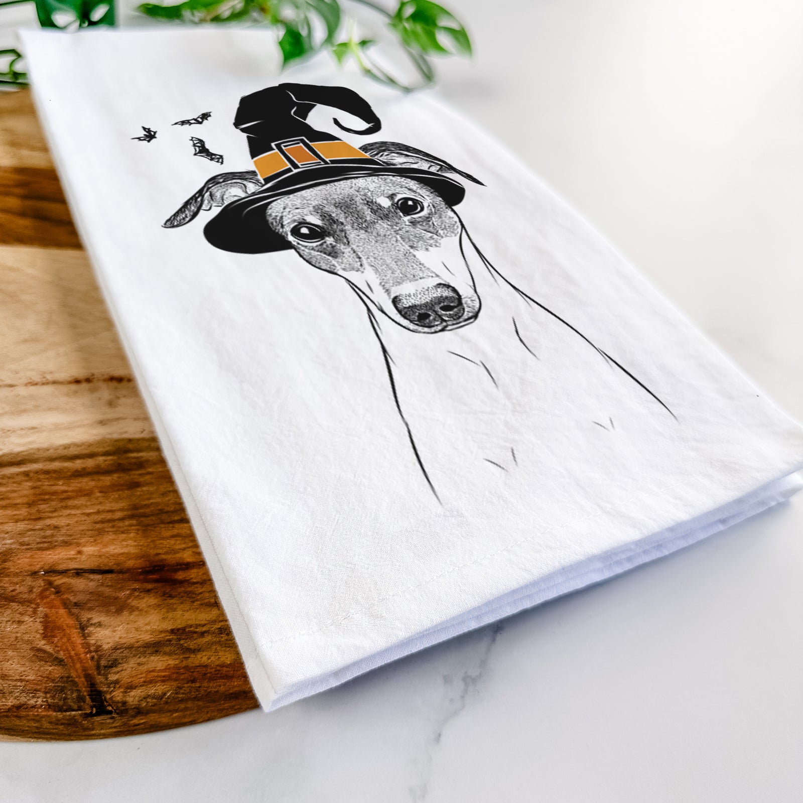Hand-drawn sketch of Momo the Japanese Terrier wearing a witch hat on a tea towel