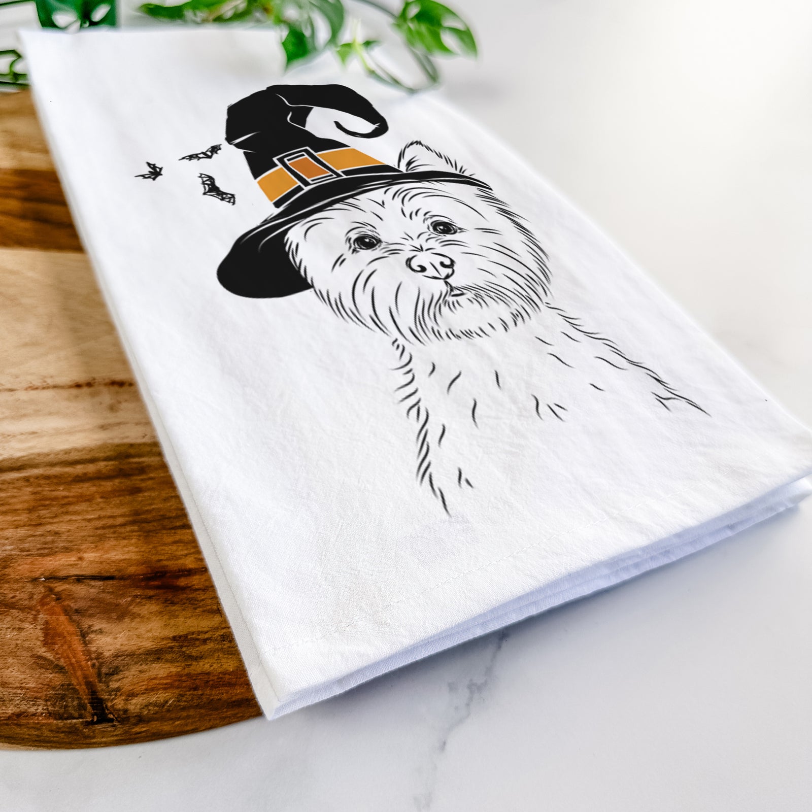 Hand-drawn sketch of Murphy the West Highland Terrier wearing a witch hat on a tea towel