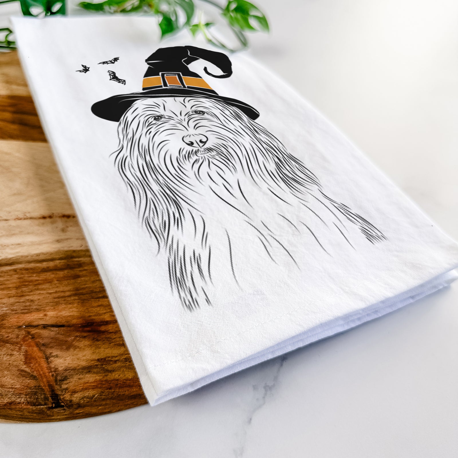 Hand-drawn sketch of Murray the Bearded Collie wearing a witch hat on a tea towel