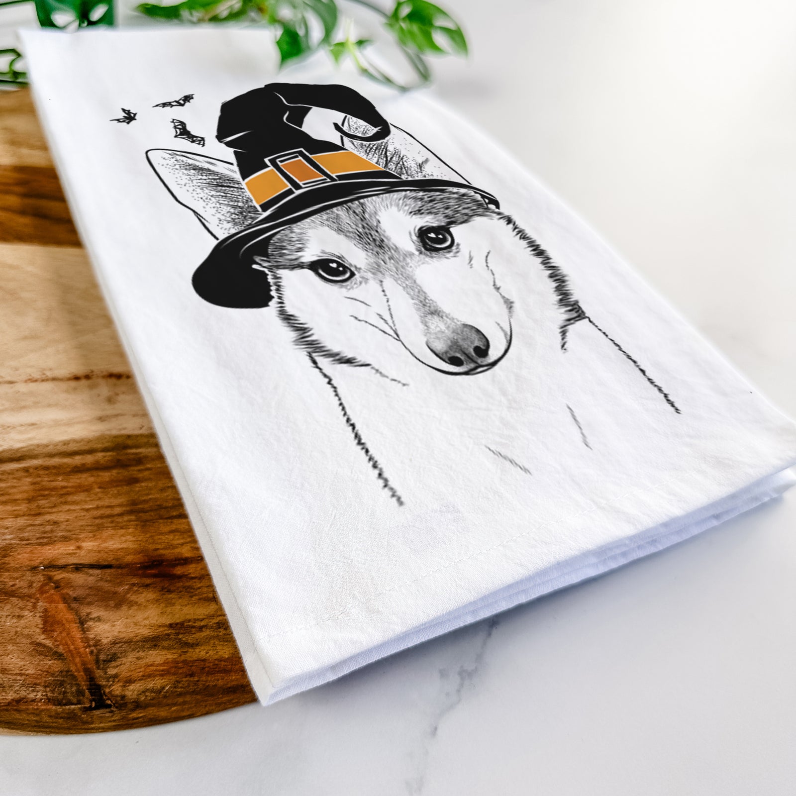 Hand-drawn sketch of Nami the Alaskan Klee Kai wearing a witch hat on a tea towel