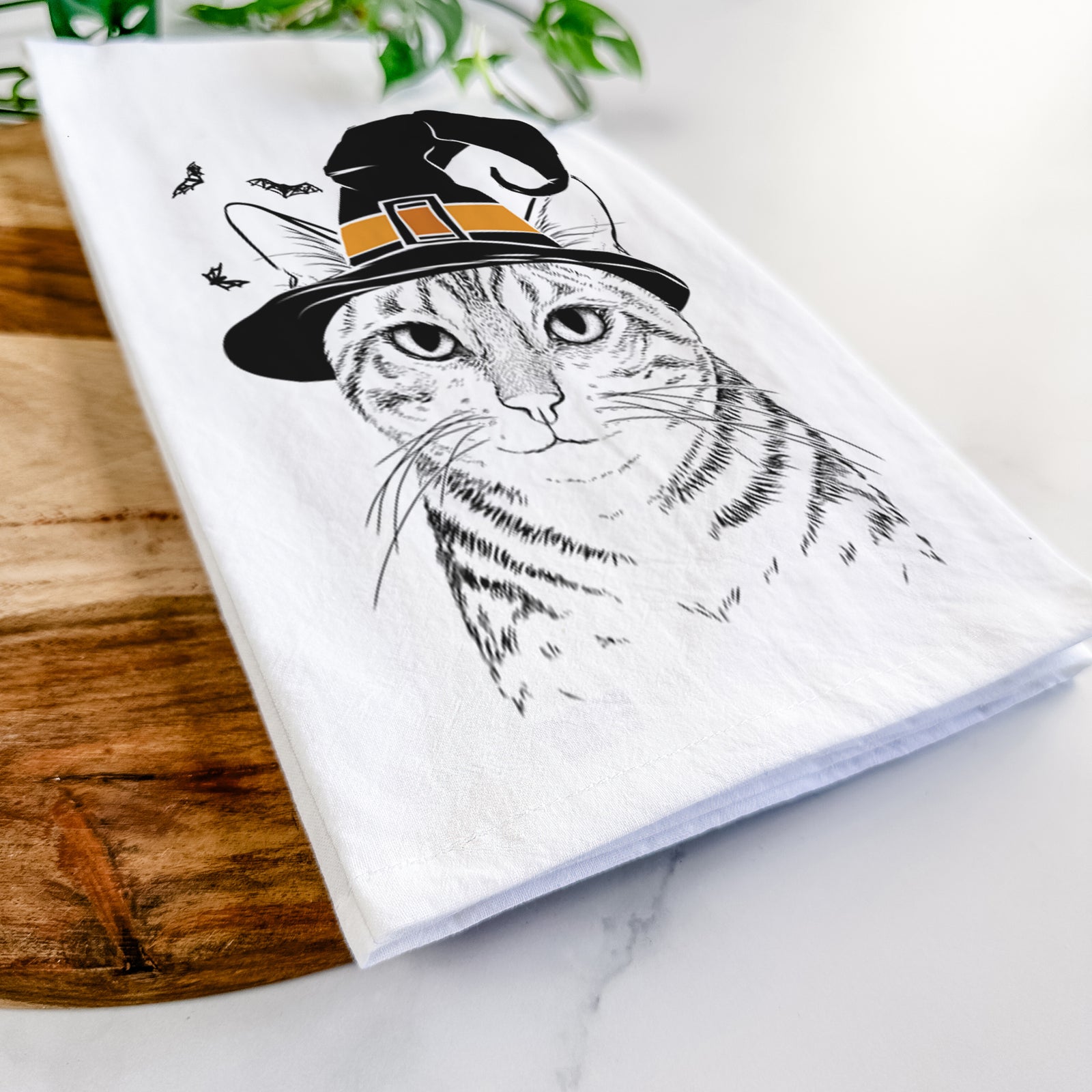 Hand-drawn sketch of Nell the Tabby Cat wearing a witch hat on a tea towel