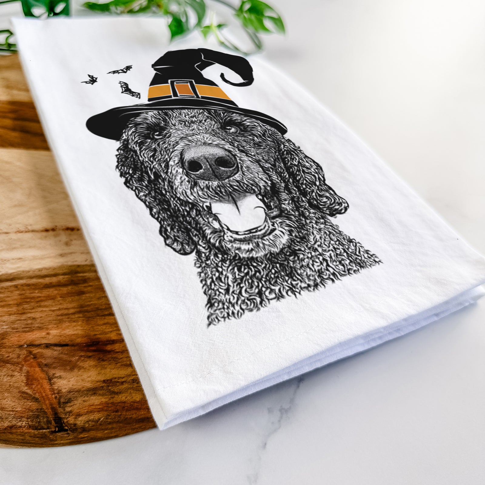 Hand-drawn sketch of Obi James the Goldendoodle wearing a witch hat on a tea towel