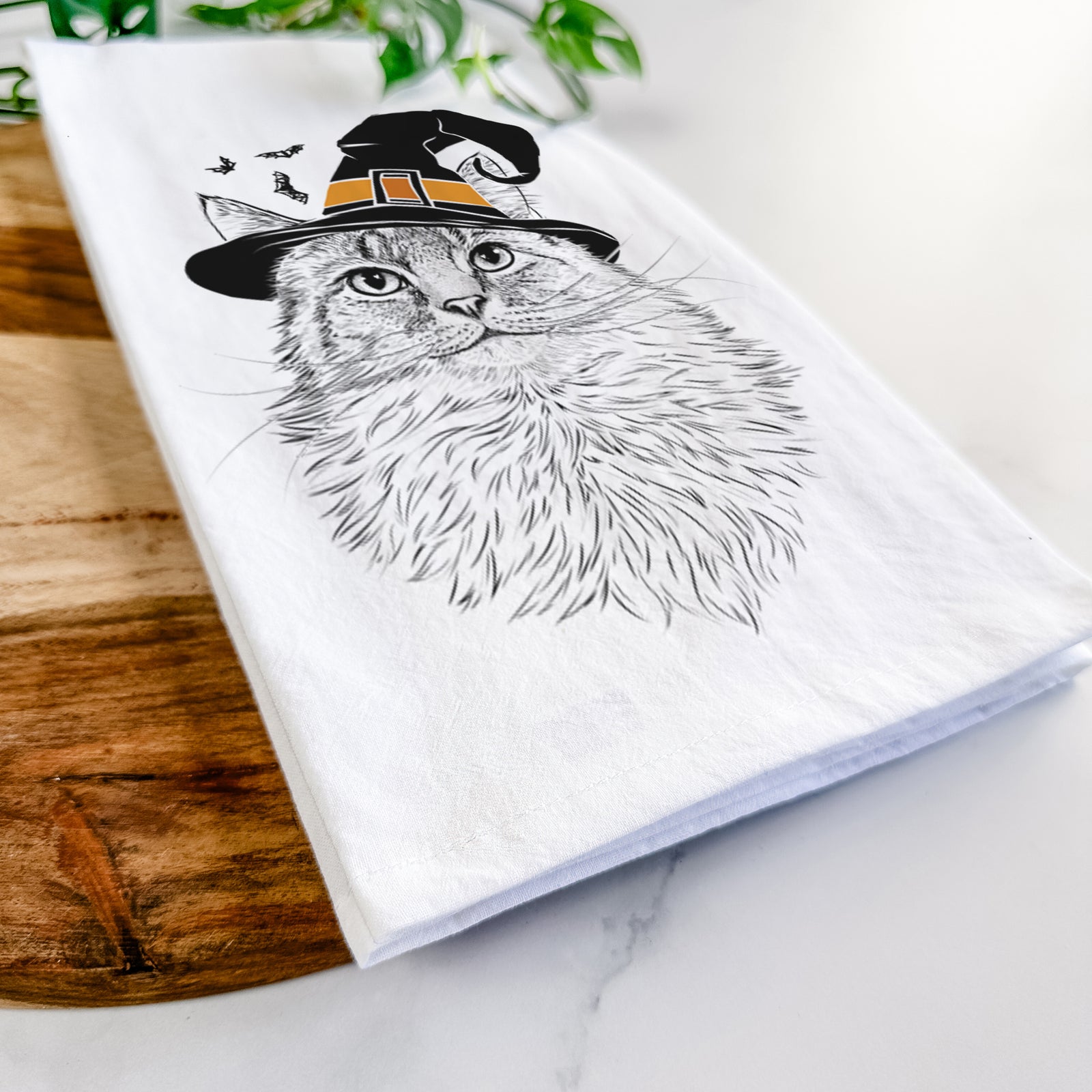 Hand-drawn sketch of Olive the Cat wearing a witch hat on a tea towel