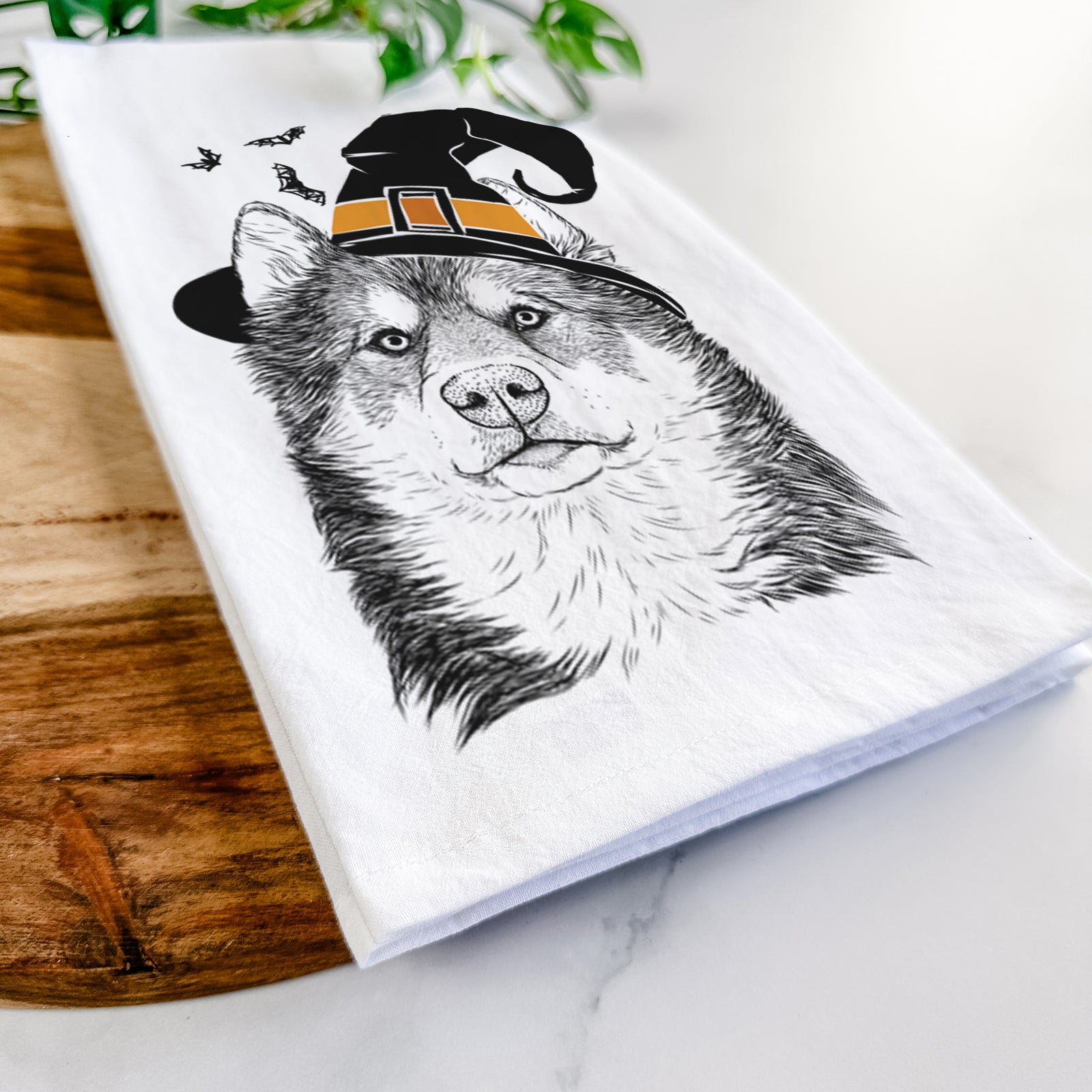 Hand-drawn sketch of Oskar the Canadian Eskimo Dog wearing a witch hat on a tea towel