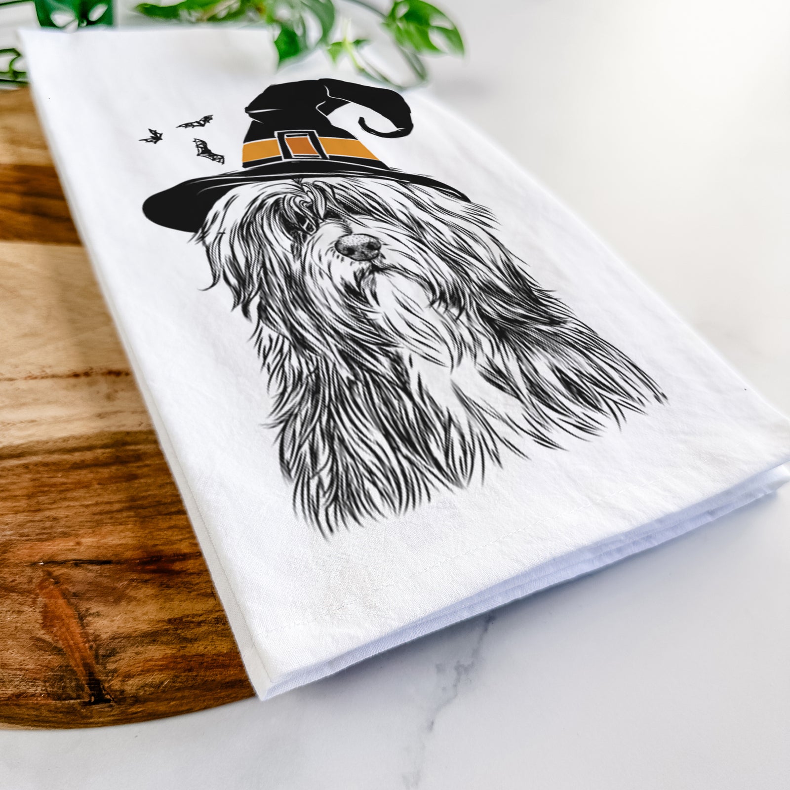 Hand-drawn sketch of Otto the Polish Lowland Sheepdog wearing a witch hat on a tea towel