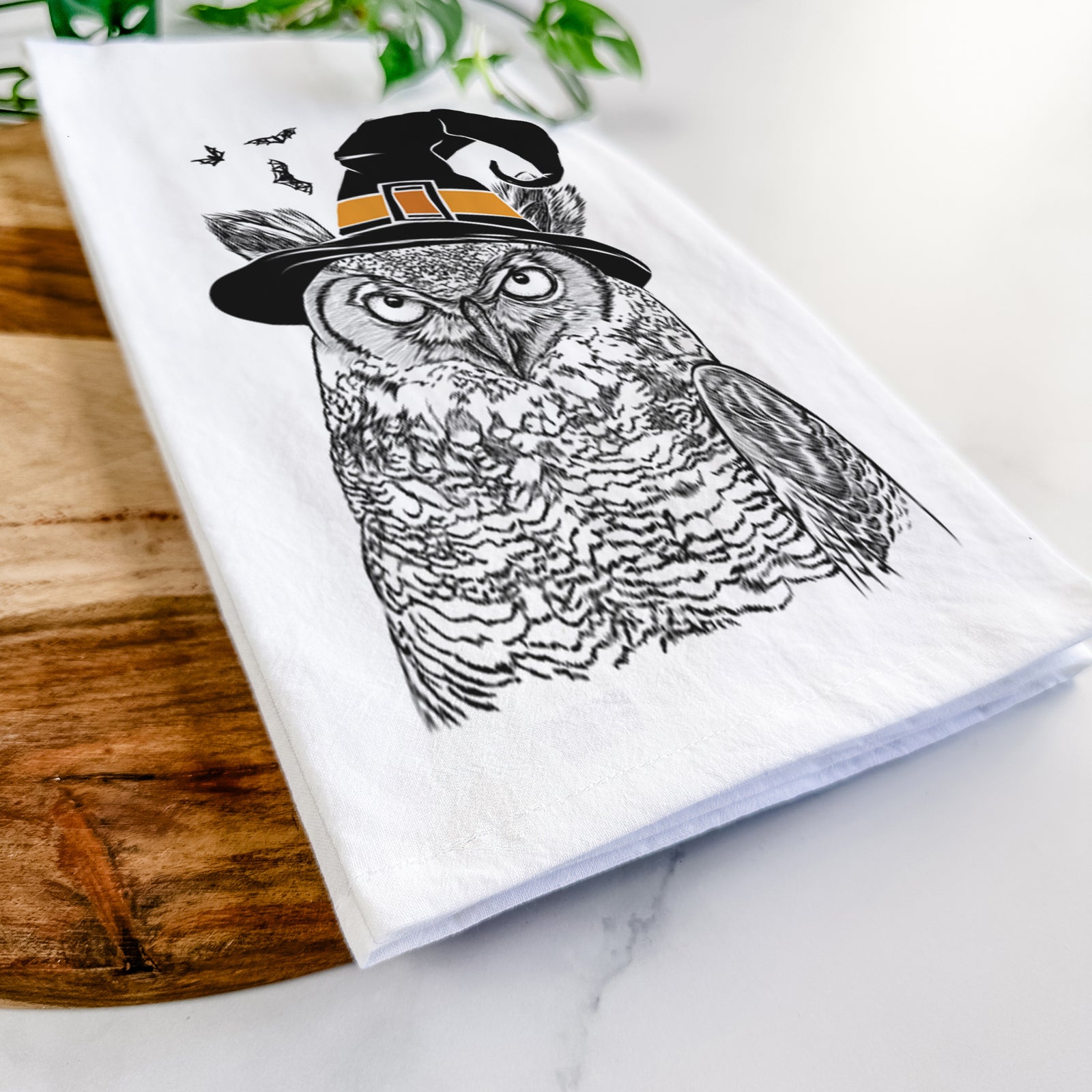 Hand-drawn sketch of Ozwald the Grey Horned Owl wearing a witch hat on a tea towel