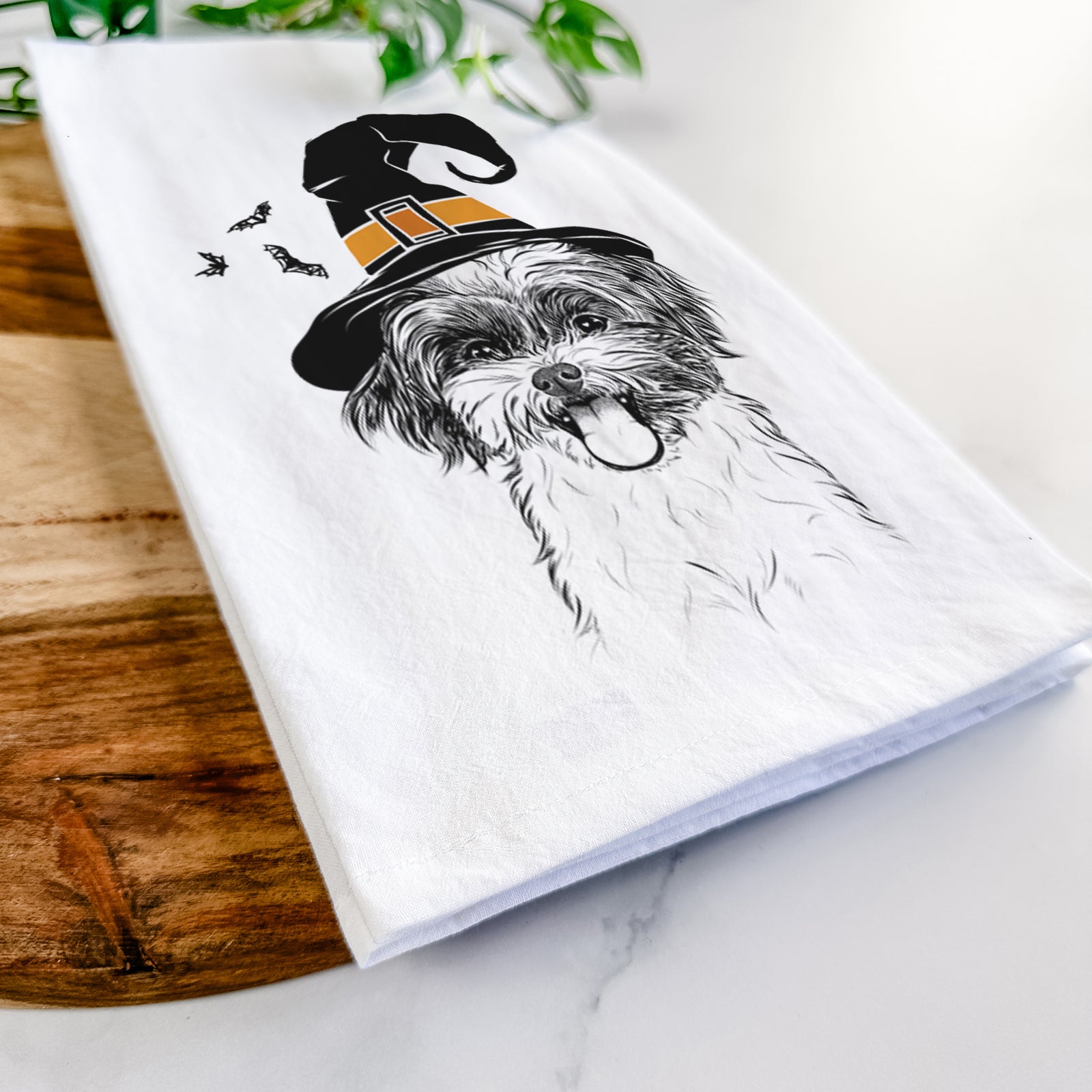 Hand-drawn sketch of Pepper the Shihpoo wearing a witch hat on a tea towel