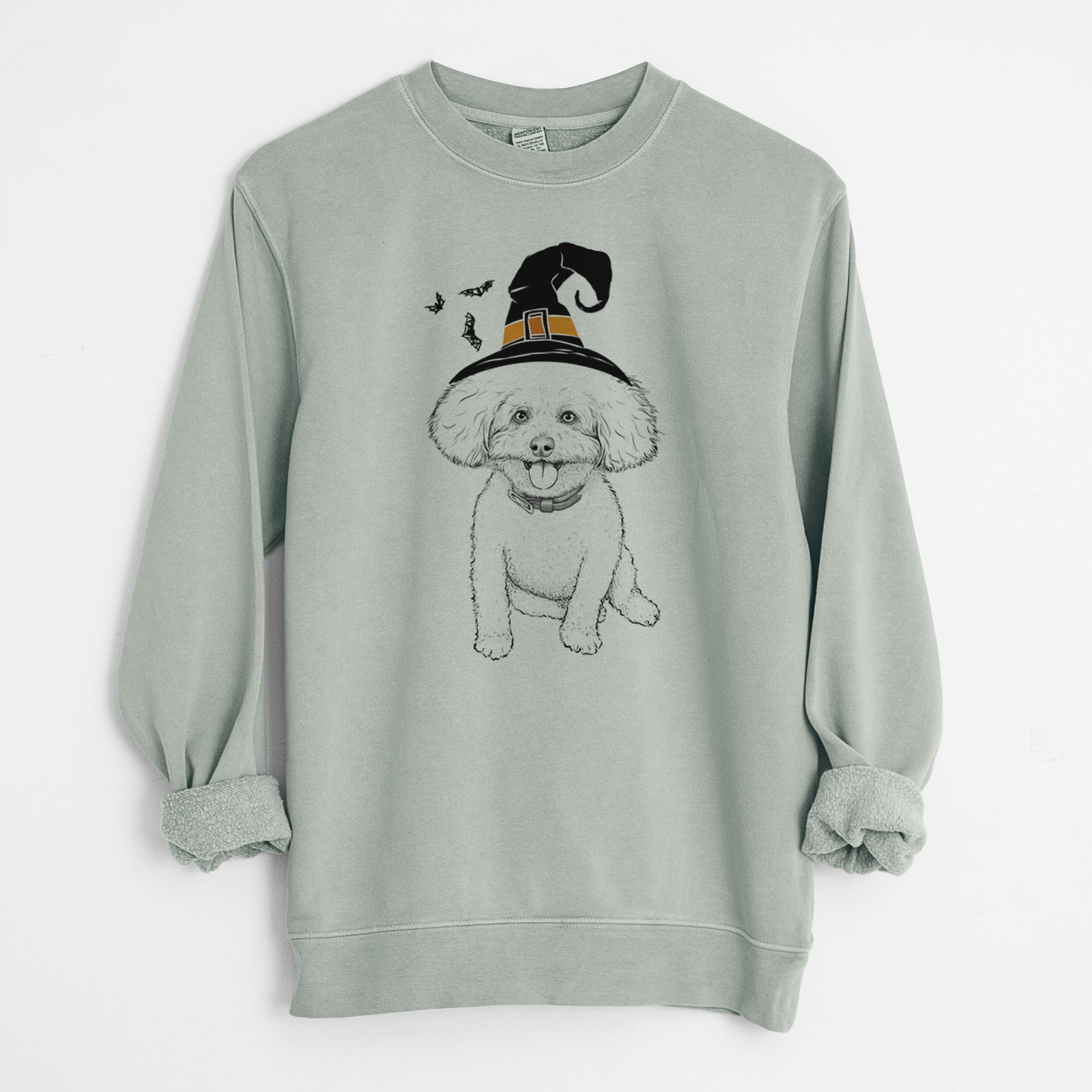 Hand-drawn sketch of Peyton the Bichon Frise wearing a witch hat on a Sage Unisex pigment dyed crew sweatshirt