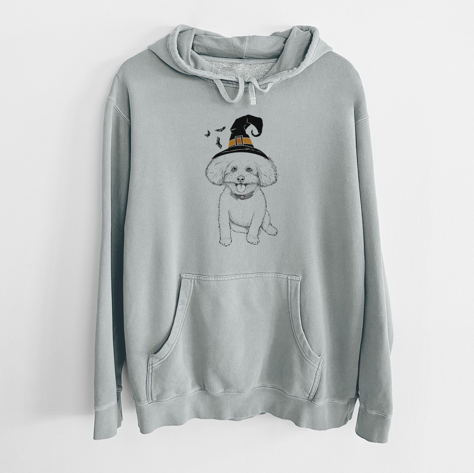 Hand-drawn sketch of Peyton the Bichon Frise wearing a witch hat on a Sage Unisex pigment dyed hoodie