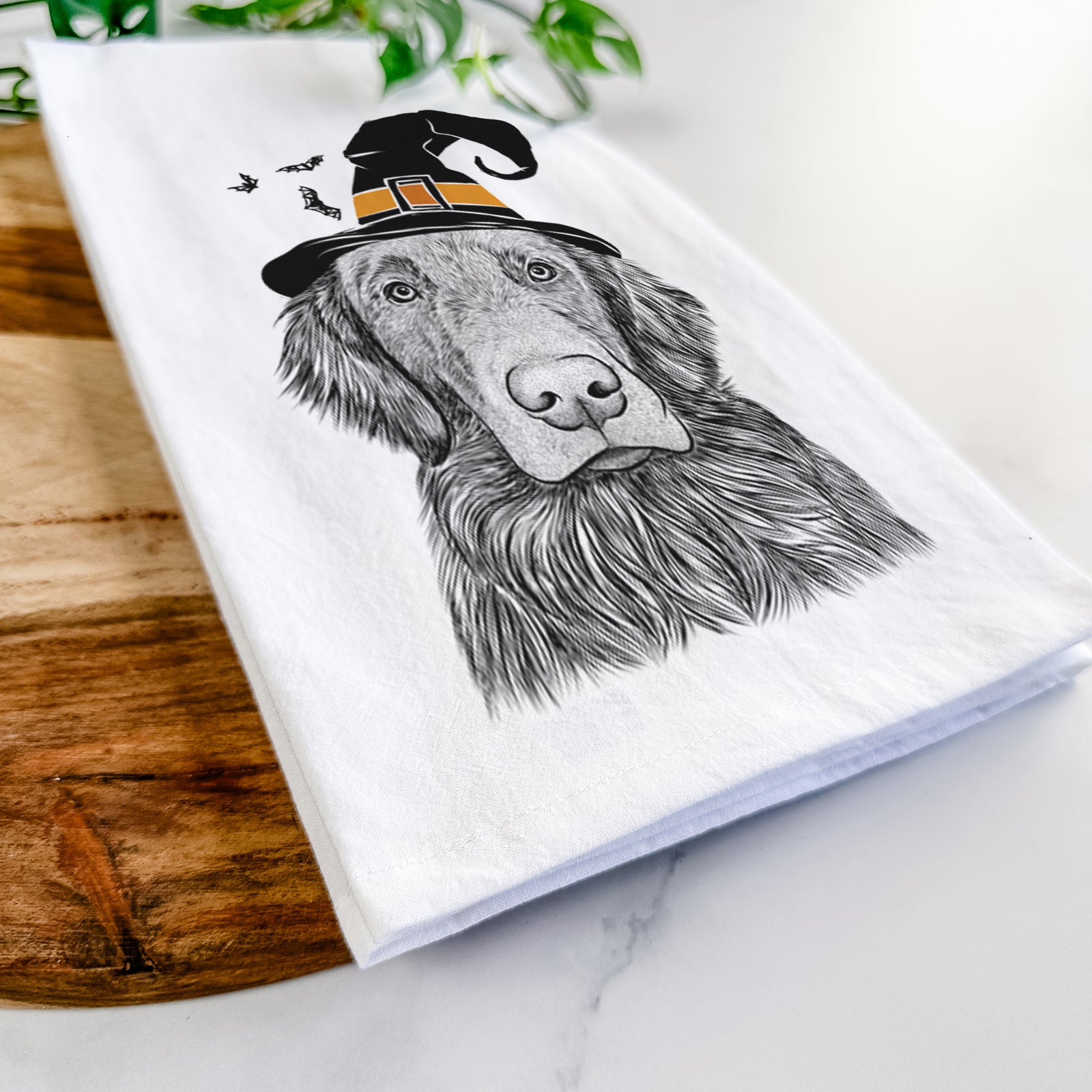 Hand-drawn sketch of Pippin the Flat Coated Retriever wearing a witch hat on a tea towel