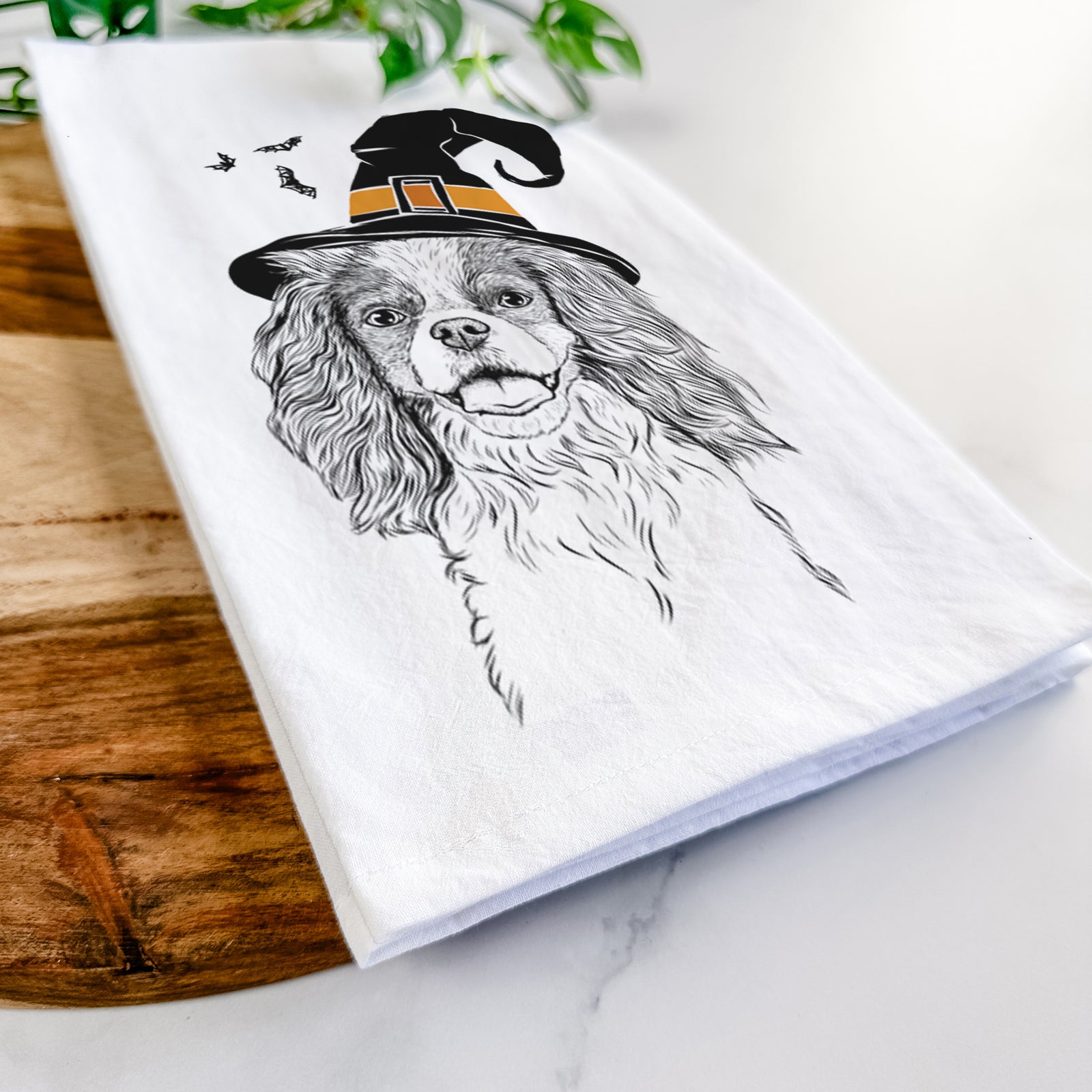 Hand-drawn sketch of Poppy the Cavalier King Charles Spaniel wearing a witch hat on a tea towel