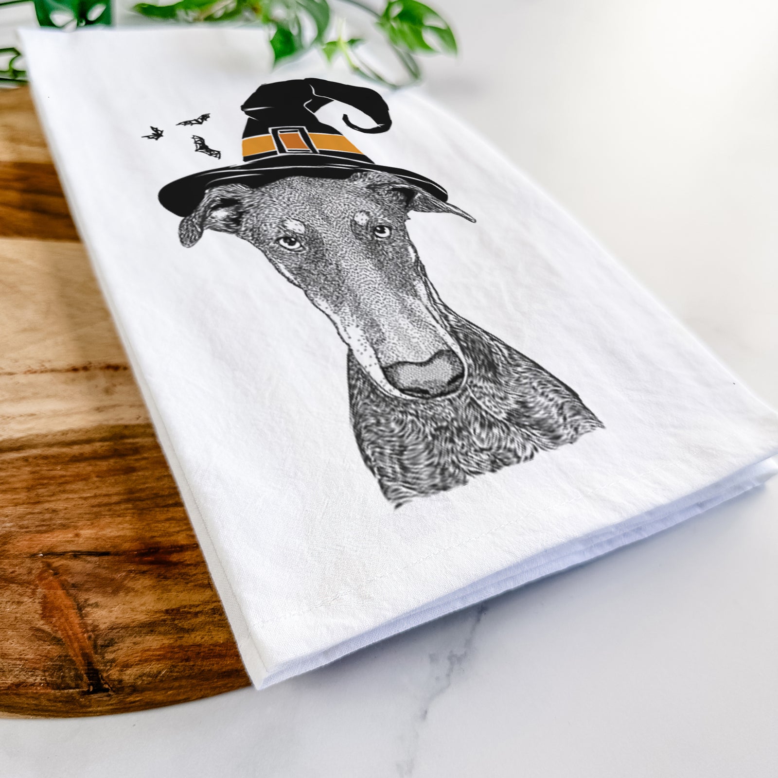 Hand-drawn sketch of Princess Fiona the Doberman Pinscher wearing a witch hat on a tea towel