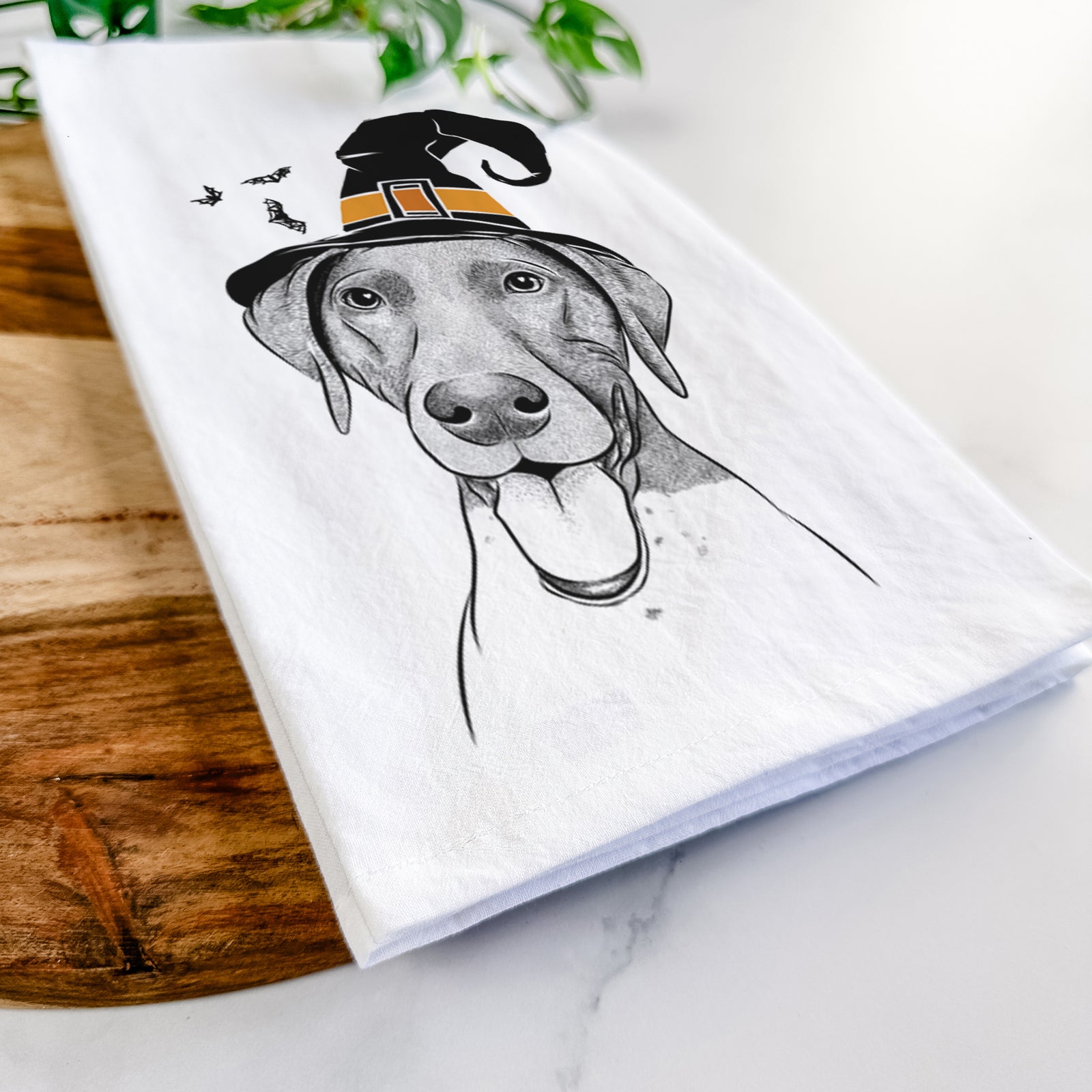 Hand-drawn sketch of Remi the German Shorthaired Pointer wearing a witch hat on a tea towel