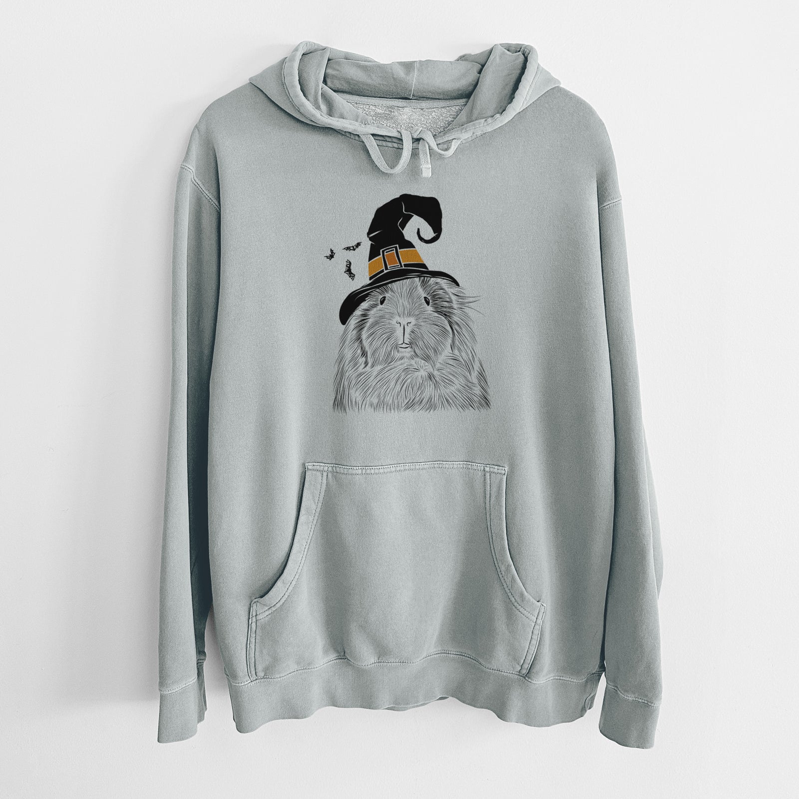 Hand-drawn sketch of Rhino the Guinea Pig wearing a witch hat on a Sage Unisex pigment dyed hoodie
