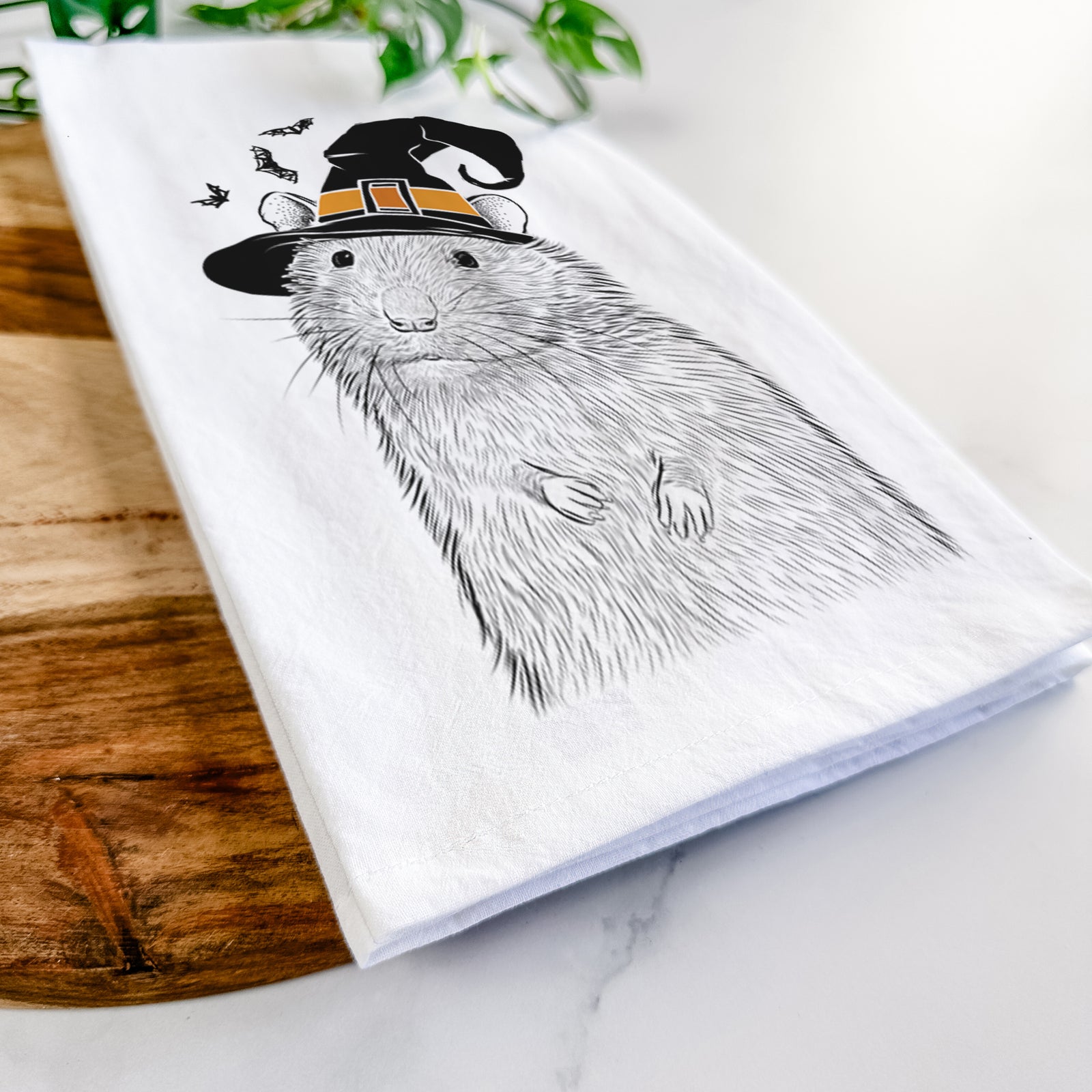 Hand-drawn sketch of Rizzo the Rat wearing a witch hat on a tea towel