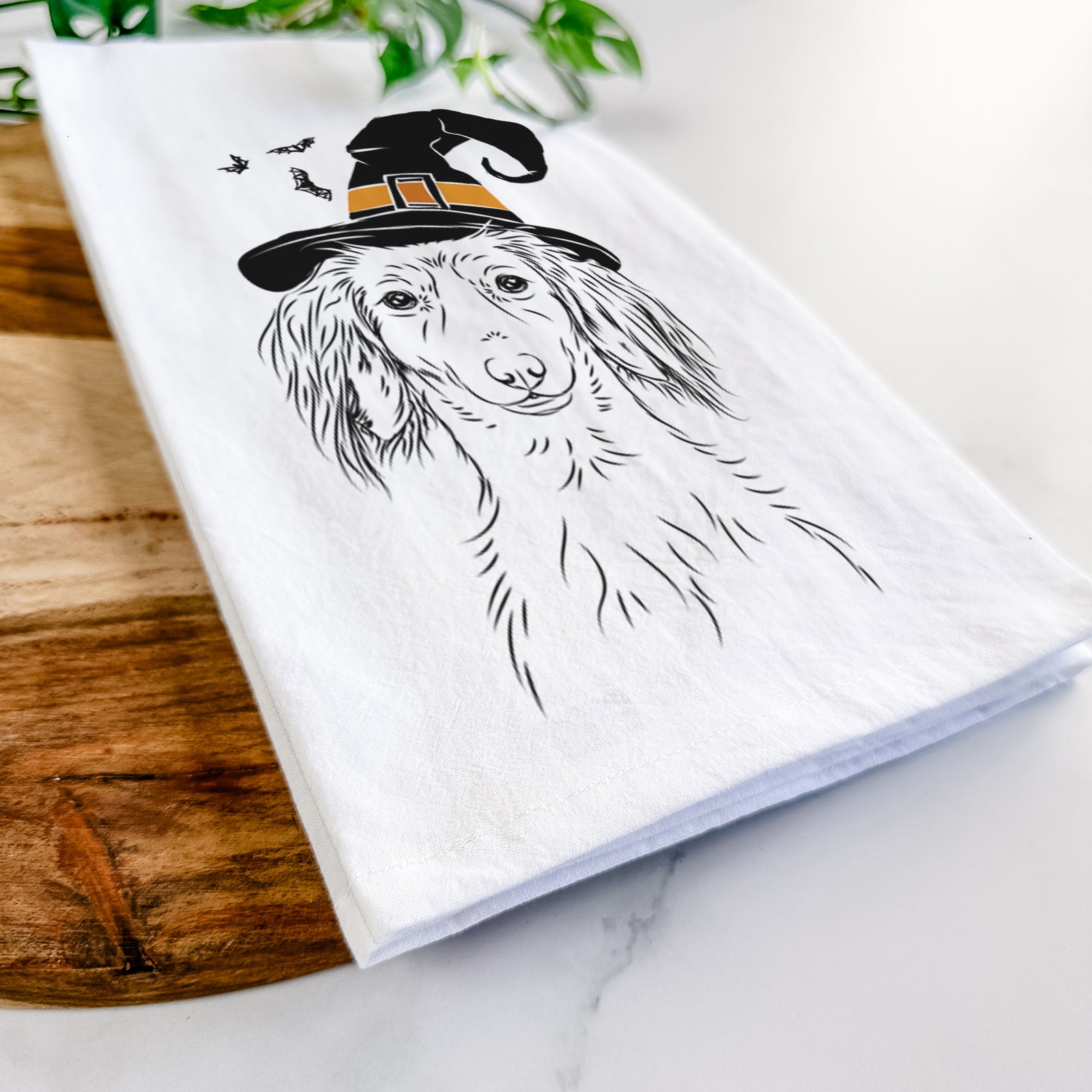 Hand-drawn sketch of Roux the Long Haired Dachshund wearing a witch hat on a tea towel