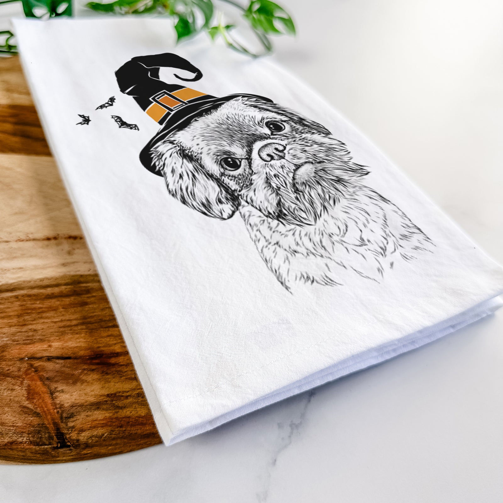 Hand-drawn sketch of Rufus the Shiffon wearing a witch hat on a tea towel