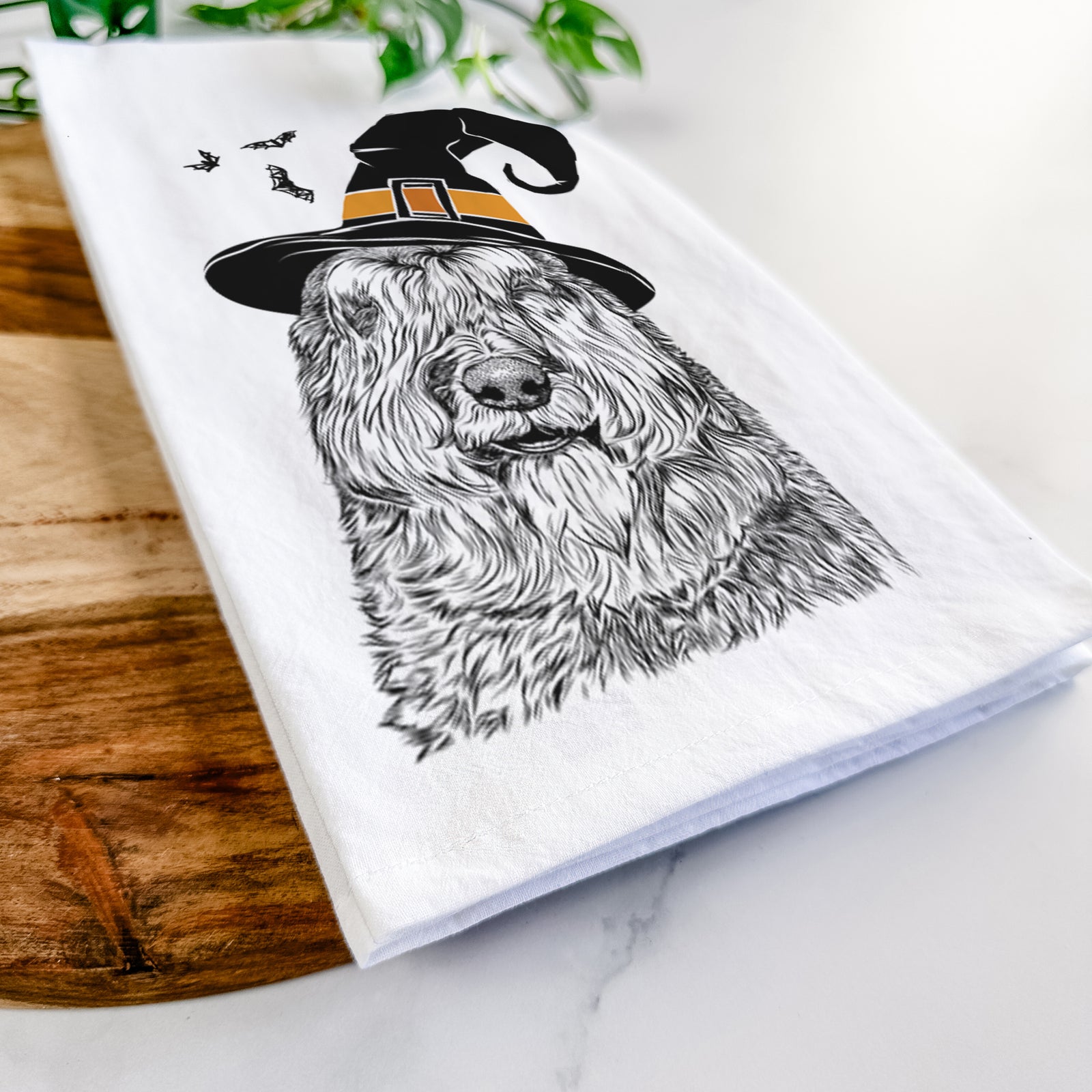 Hand-drawn sketch of Sabre the Bouvier Des Flandres wearing a witch hat on a tea towel