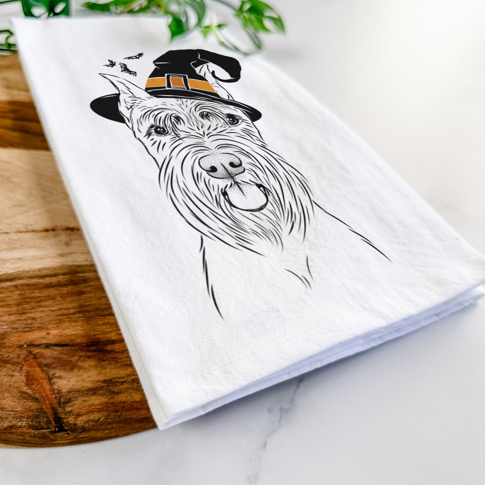 Hand-drawn sketch of Samuel the Standard Schnauzer wearing a witch hat on a tea towel
