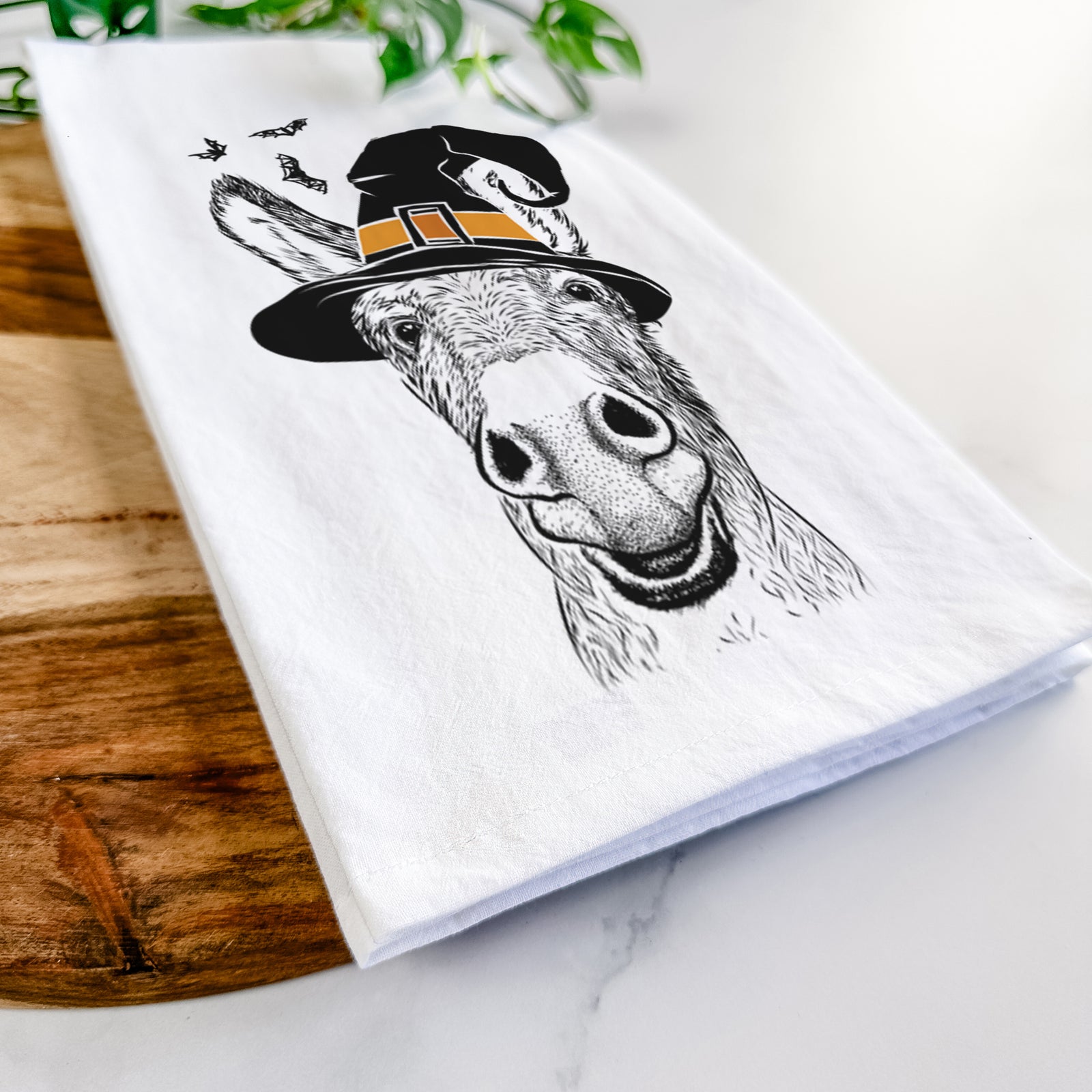 Hand-drawn sketch of Samule the Donkey wearing a witch hat on a tea towel