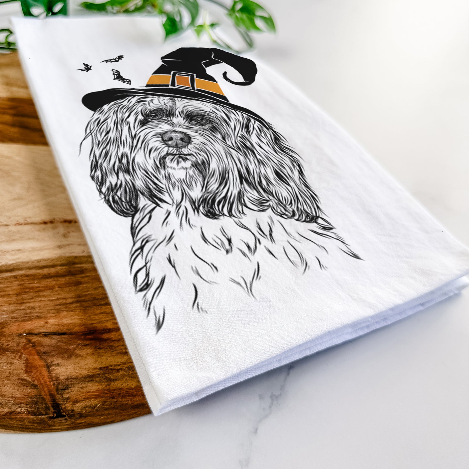 Hand-drawn sketch of Shenpa the Tibetan Terrier wearing a witch hat on a tea towel