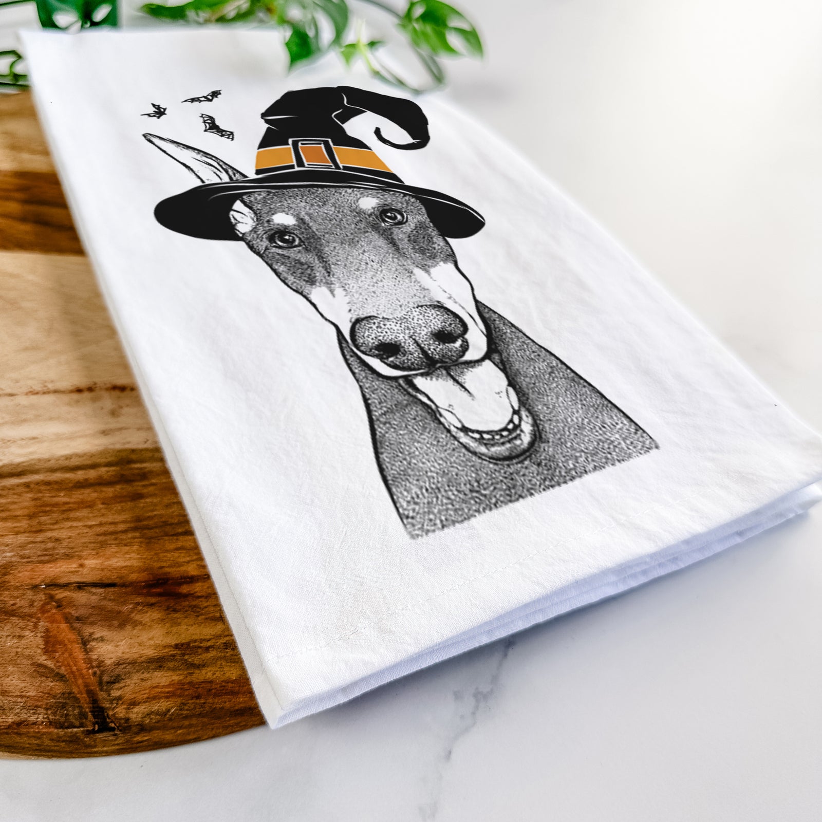 Hand-drawn sketch of Sir Duke the Doberman Pinscher wearing a witch hat on a tea towel