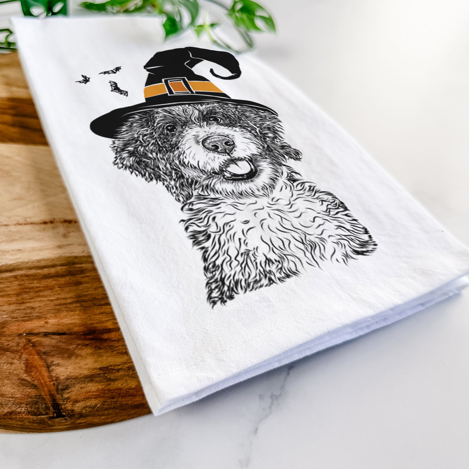 Hand-drawn sketch of Smoky the Bernedoodle Puppy wearing a witch hat on a tea towel