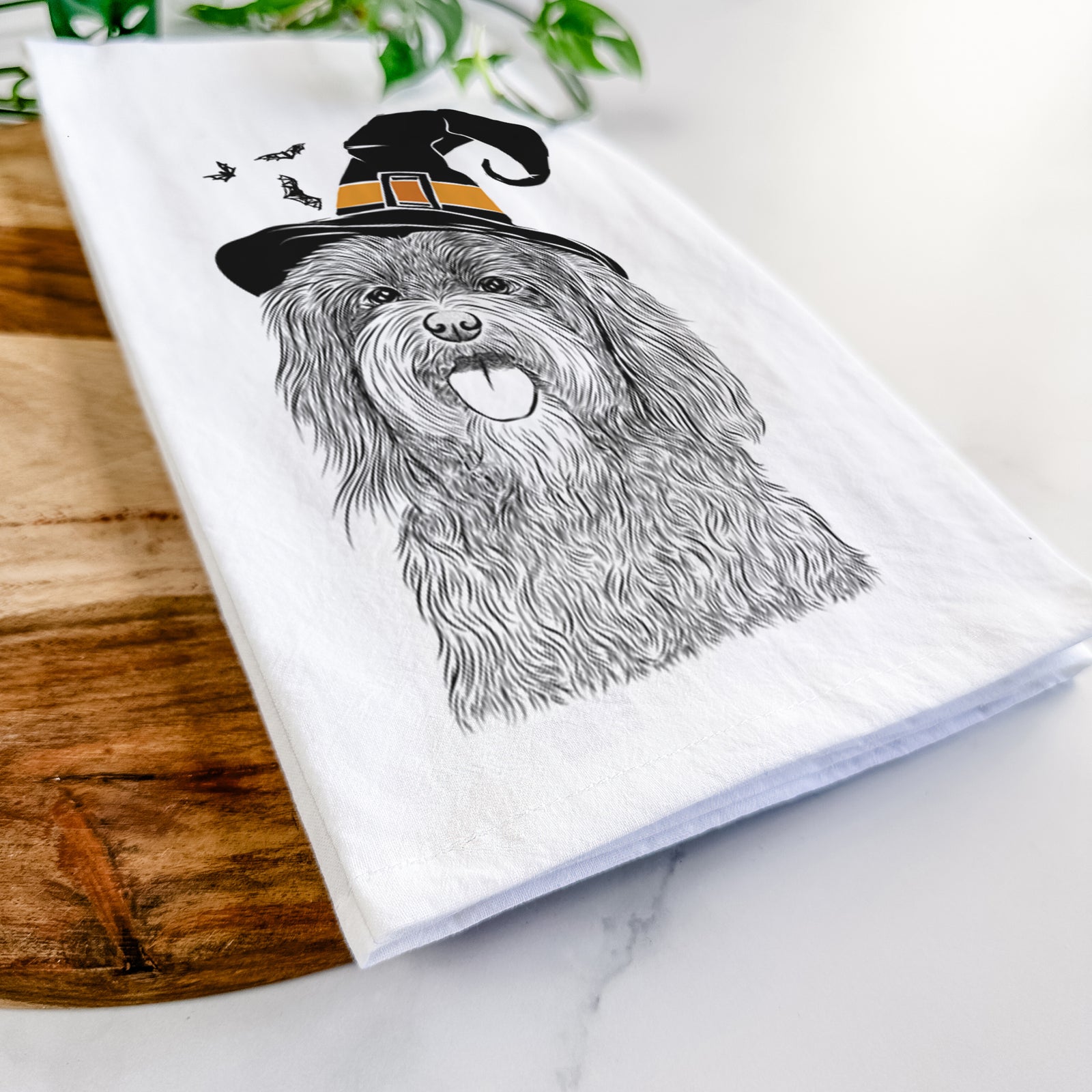 Hand-drawn sketch of Sophie the Havanese wearing a witch hat on a tea towel