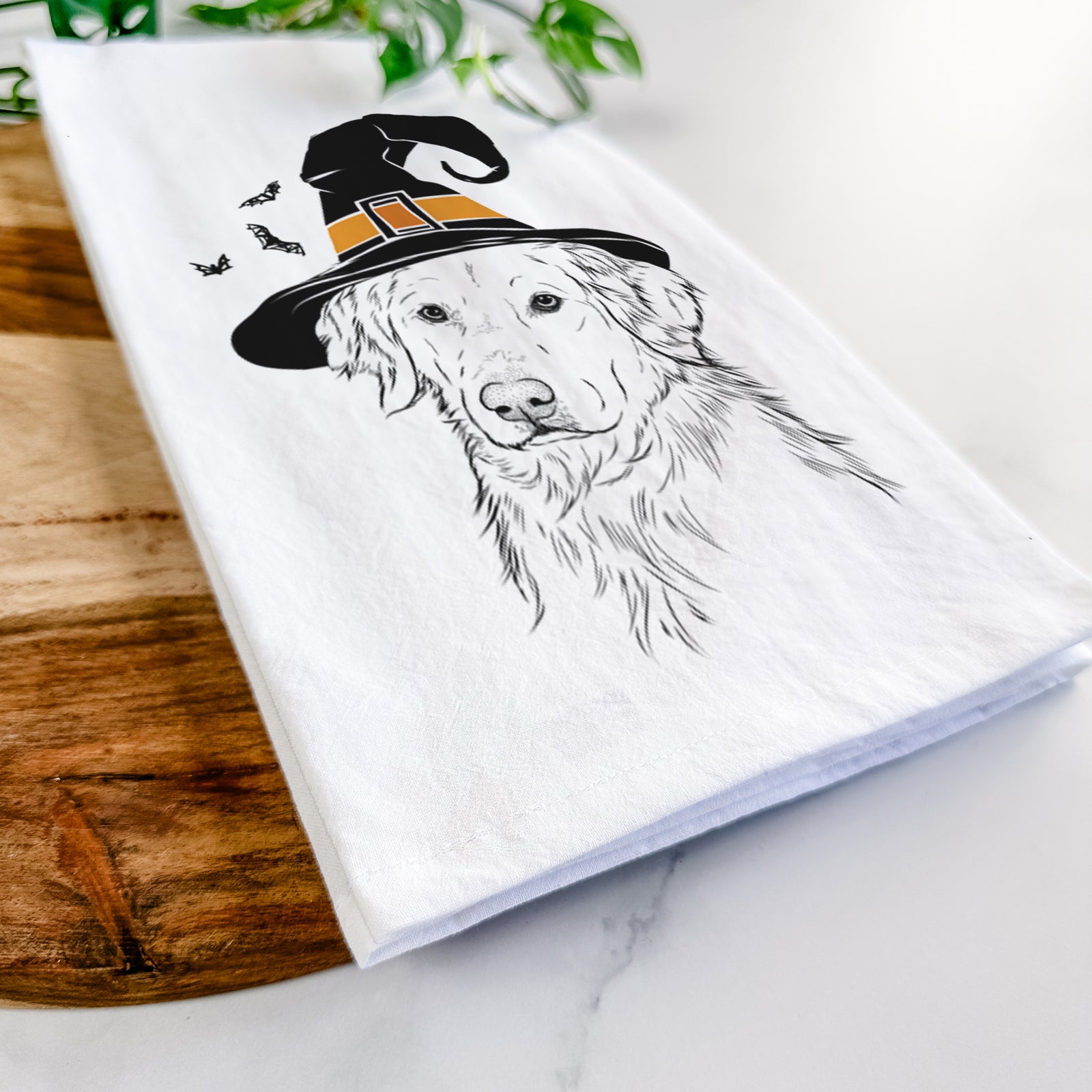 Hand-drawn sketch of Spencer the Golden Retriever wearing a witch hat on a tea towel