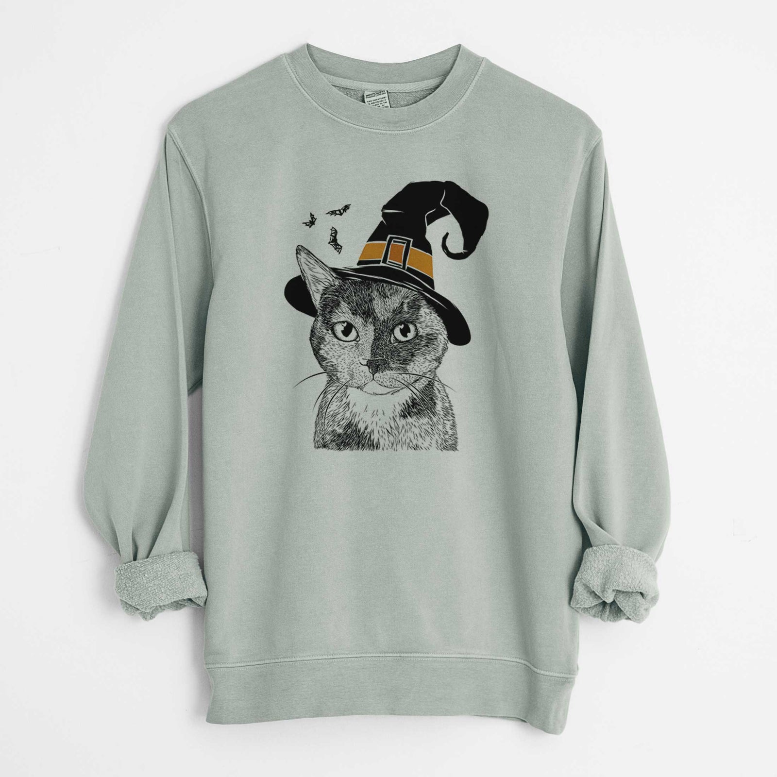 Hand-drawn sketch of Spooky Kitty the Tortoiseshell Cat wearing a witch hat on a Sage Unisex pigment dyed crew sweatshirt