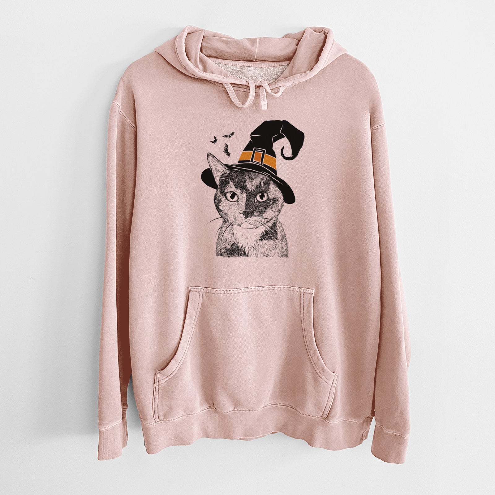 Hand-drawn sketch of Spooky Kitty the Tortoiseshell Cat wearing a witch hat on a Dusty Pink Unisex pigment dyed hoodie