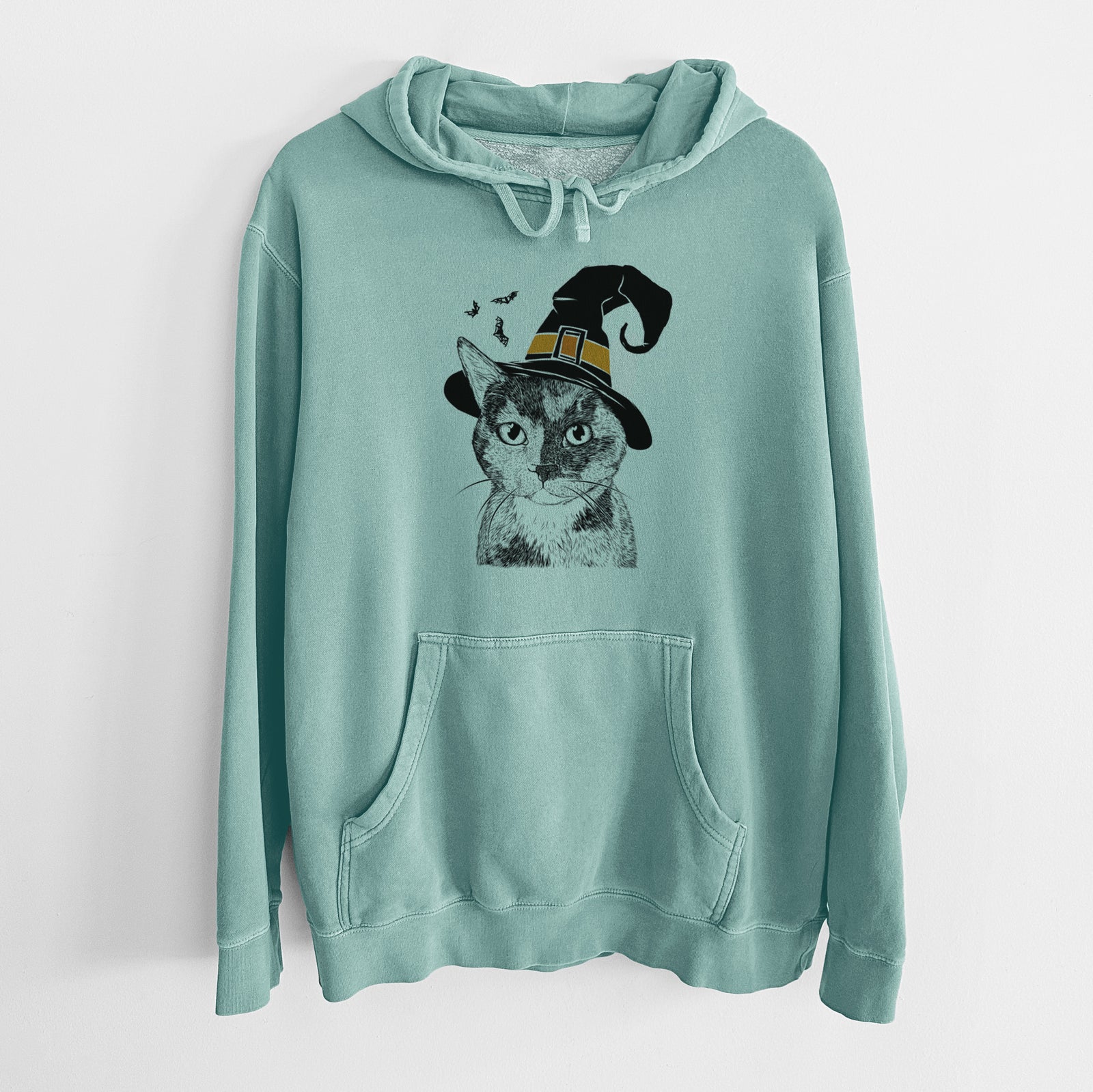Hand-drawn sketch of Spooky Kitty the Tortoiseshell Cat wearing a witch hat on a Mint Unisex pigment dyed hoodie