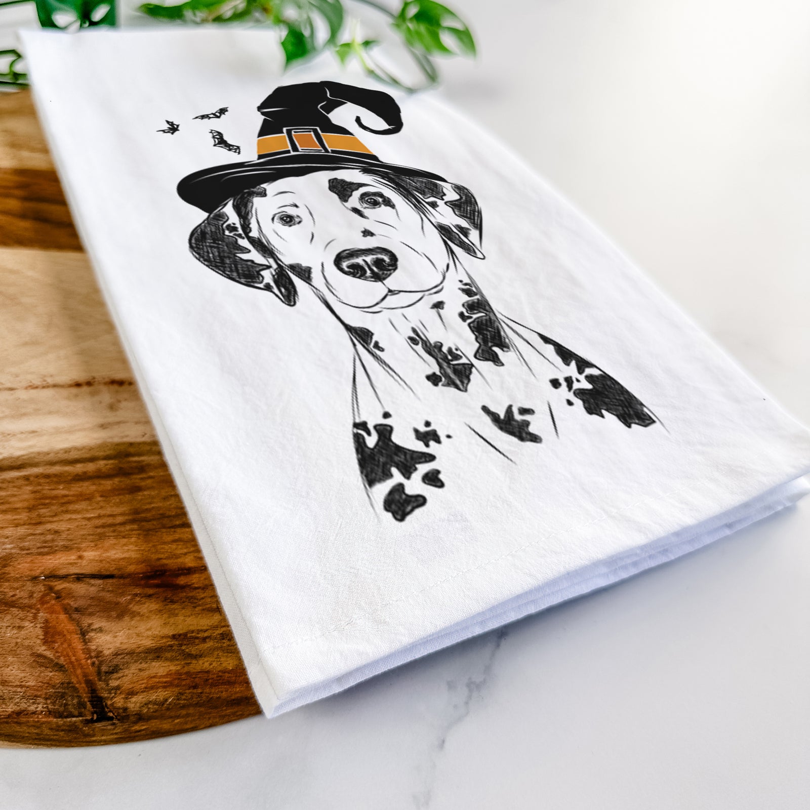 Hand-drawn sketch of Spot the Dalmatian wearing a witch hat on a tea towel