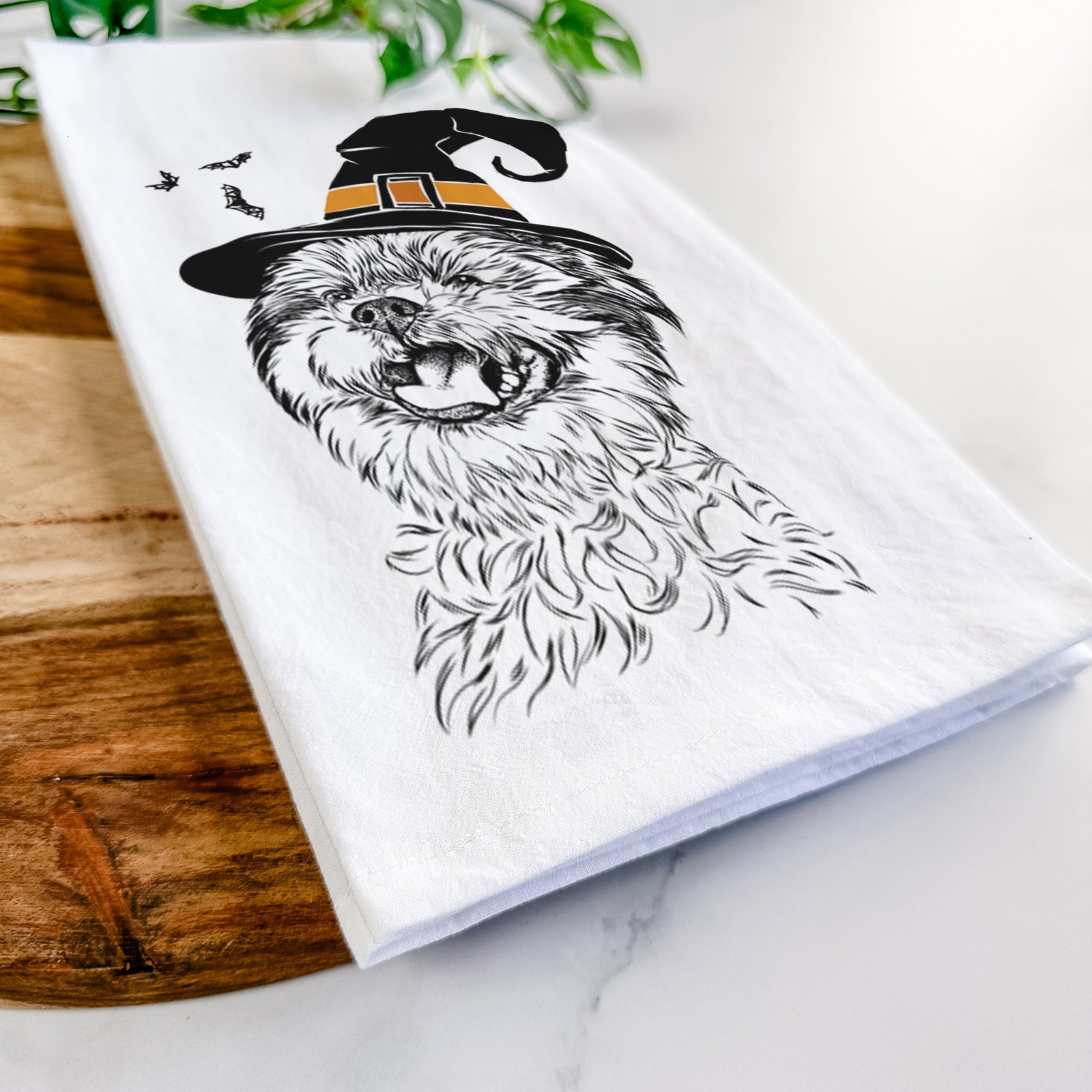 Hand-drawn sketch of Sugar the Malshi wearing a witch hat on a tea towel
