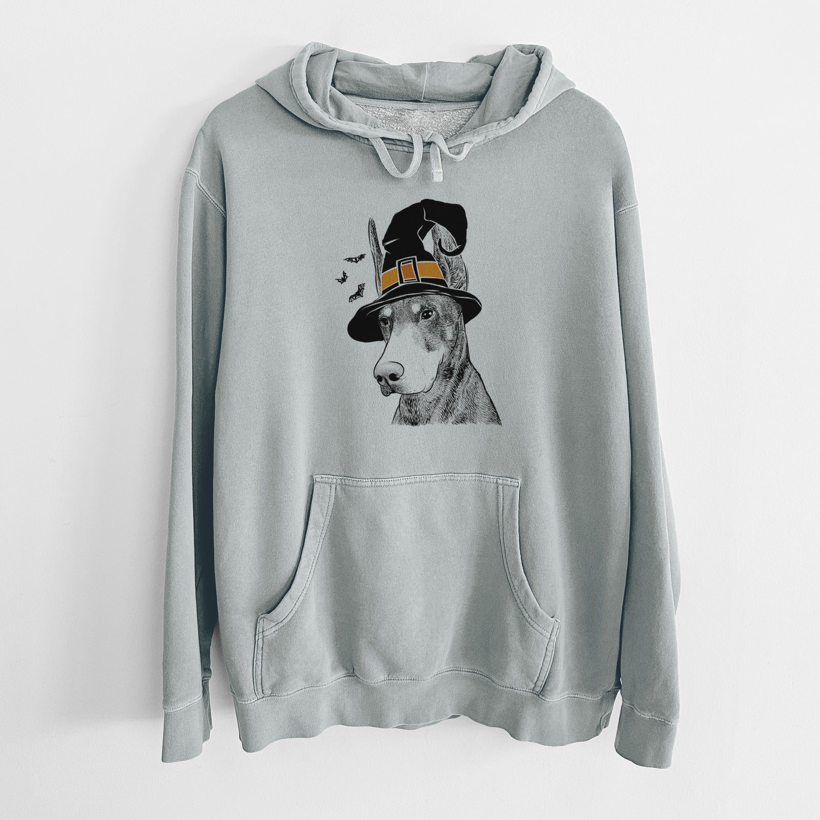 Hand-drawn sketch of Sunny the Doberman Pinscher wearing a witch hat on a Sage Unisex pigment dyed hoodie