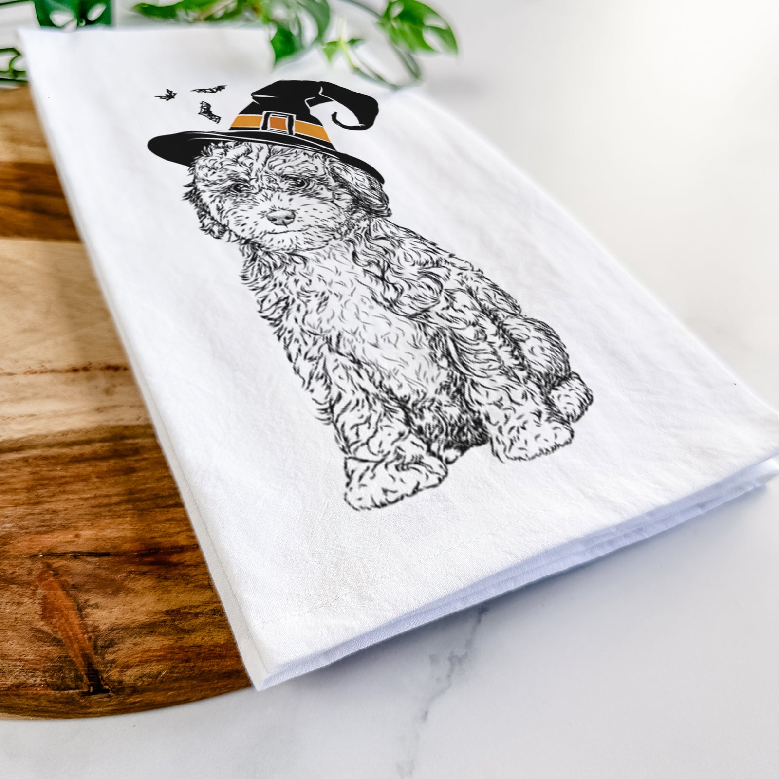 Hand-drawn sketch of Sweet Tea the Mini Doodle wearing a witch hat on a tea towel