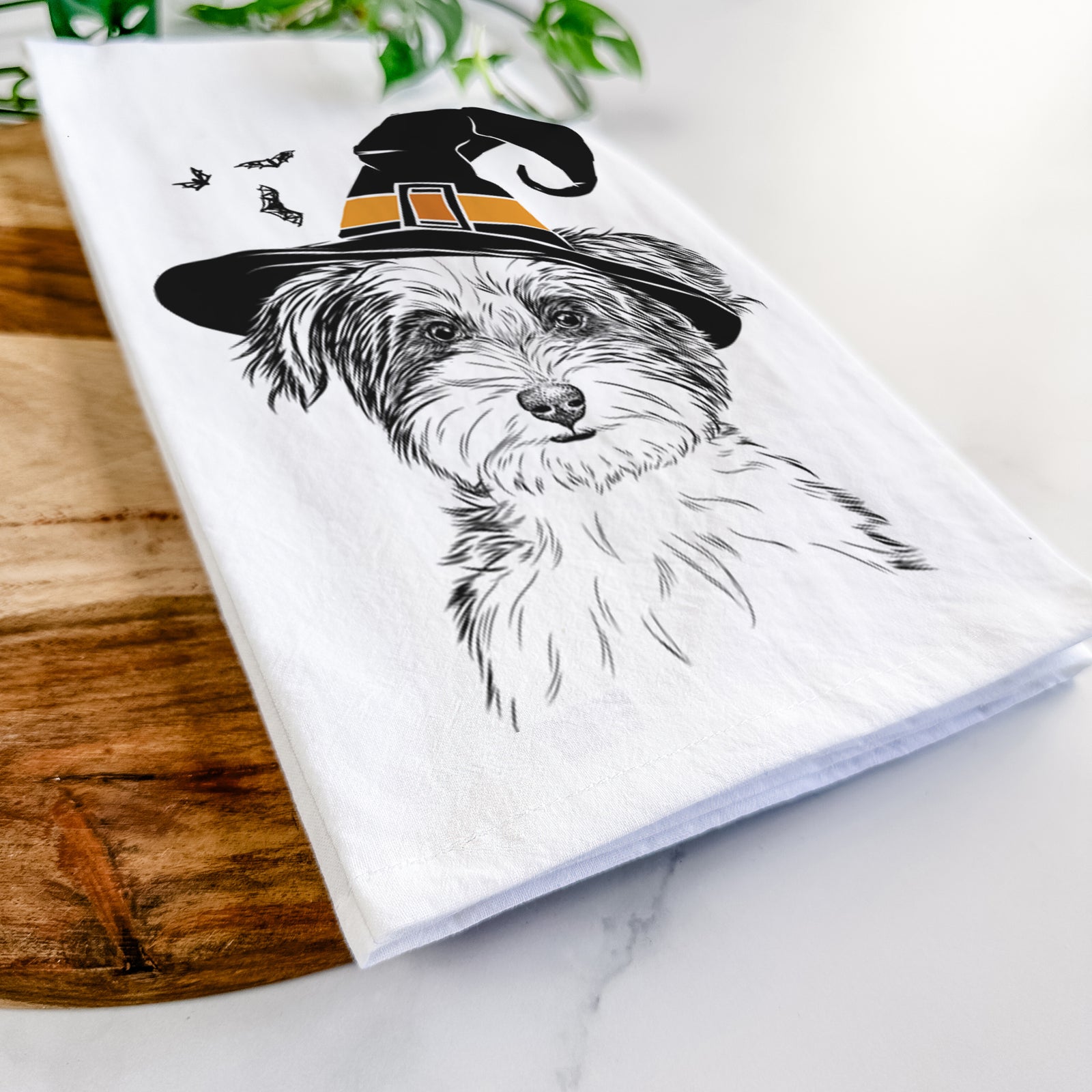 Hand-drawn sketch of Teddy the Havanese wearing a witch hat on a tea towel