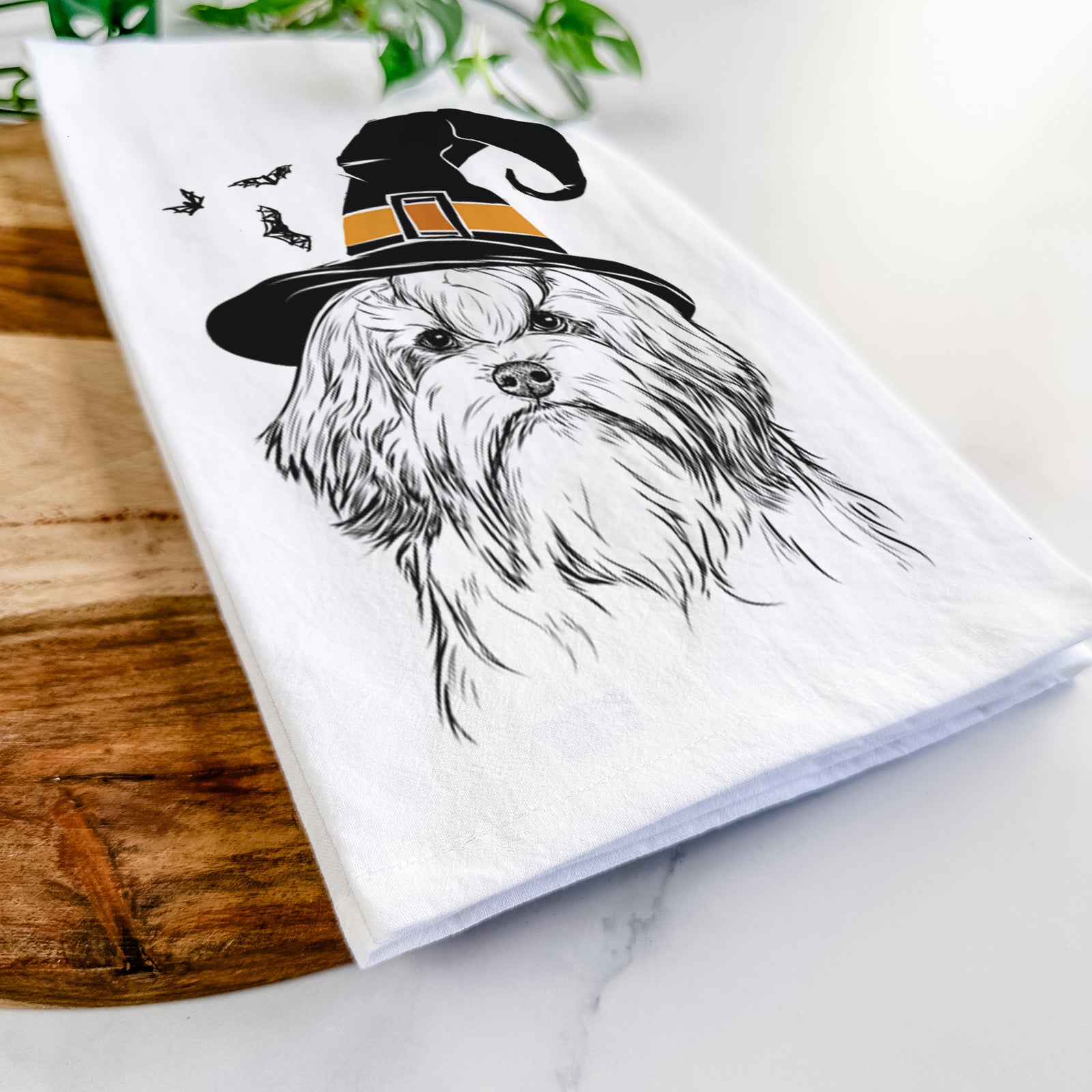 Hand-drawn sketch of Tootsie the Lowchen wearing a witch hat on a tea towel