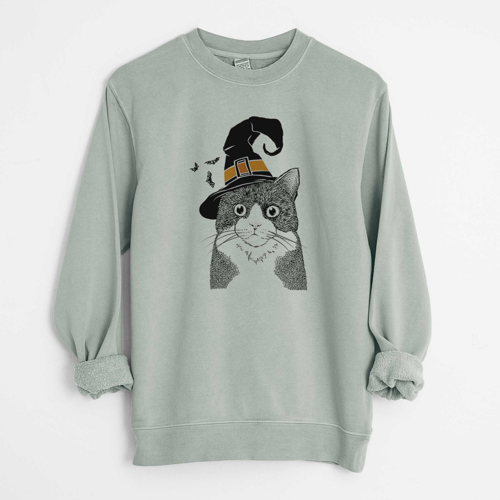 Hand-drawn sketch of Tux the Tuxedo Cat wearing a witch hat on a Sage Unisex pigment dyed crew sweatshirt