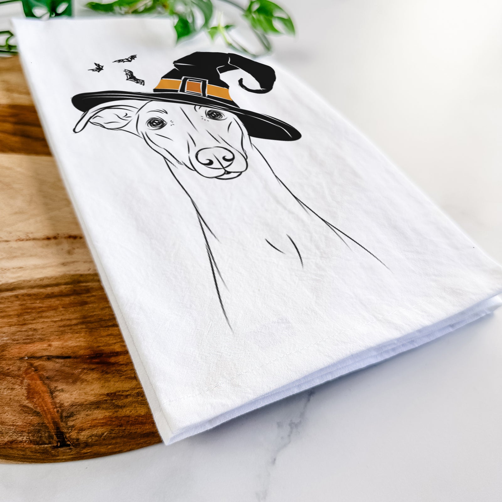 Hand-drawn sketch of Wallace the Whippet wearing a witch hat on a tea towel