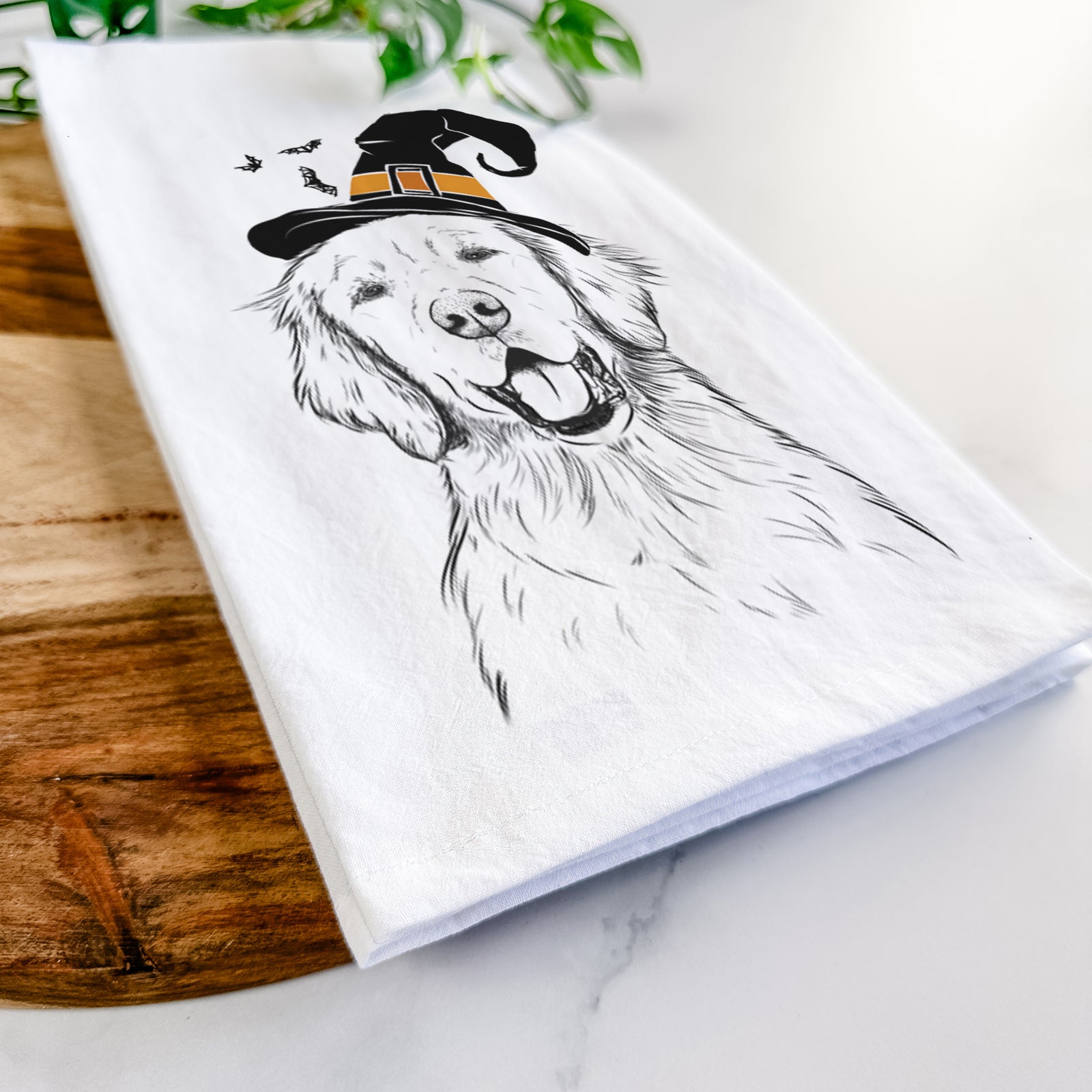 Hand-drawn sketch of Wallace the Golden Retriever wearing a witch hat on a tea towel