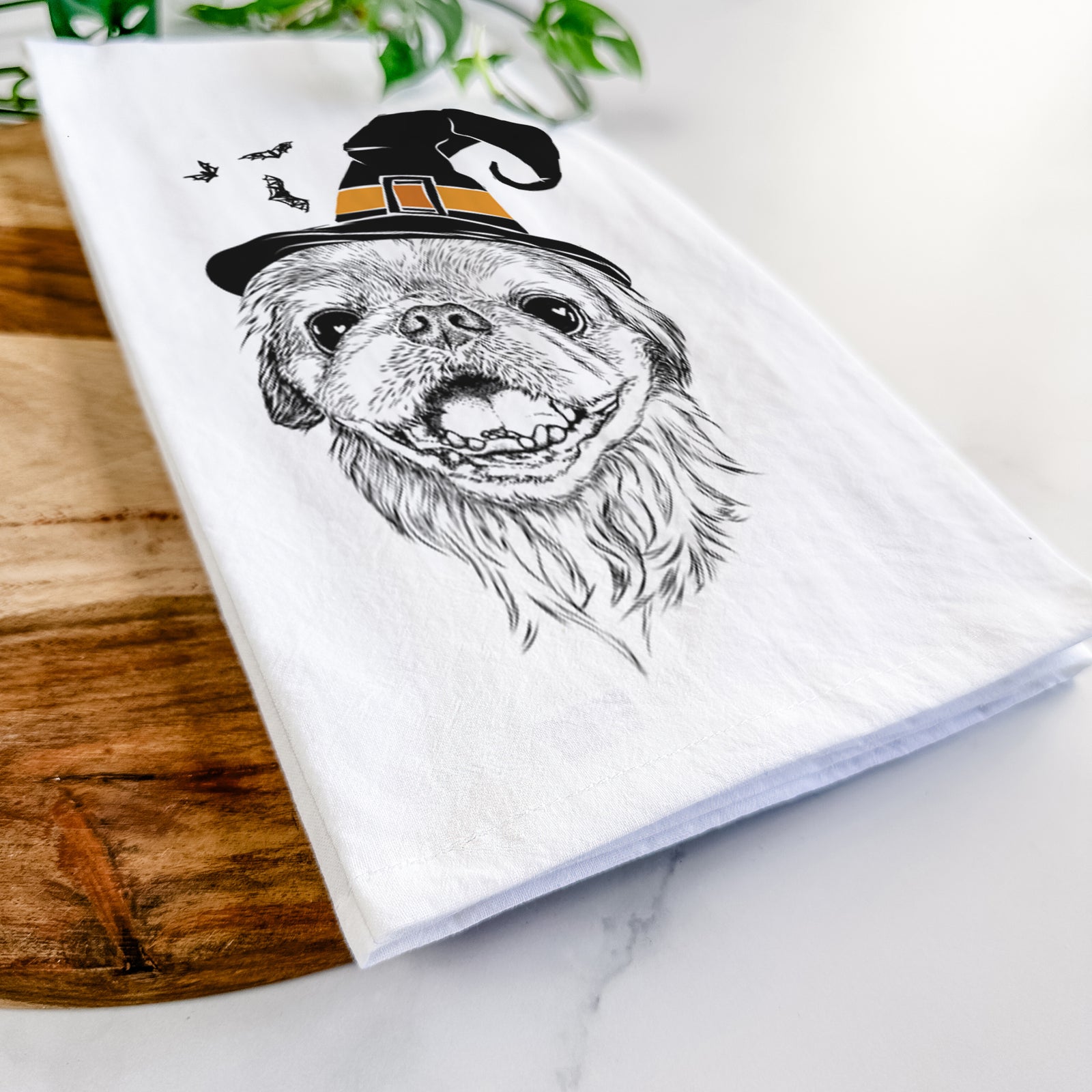Hand-drawn sketch of Wally the Pekingese wearing a witch hat on a tea towel