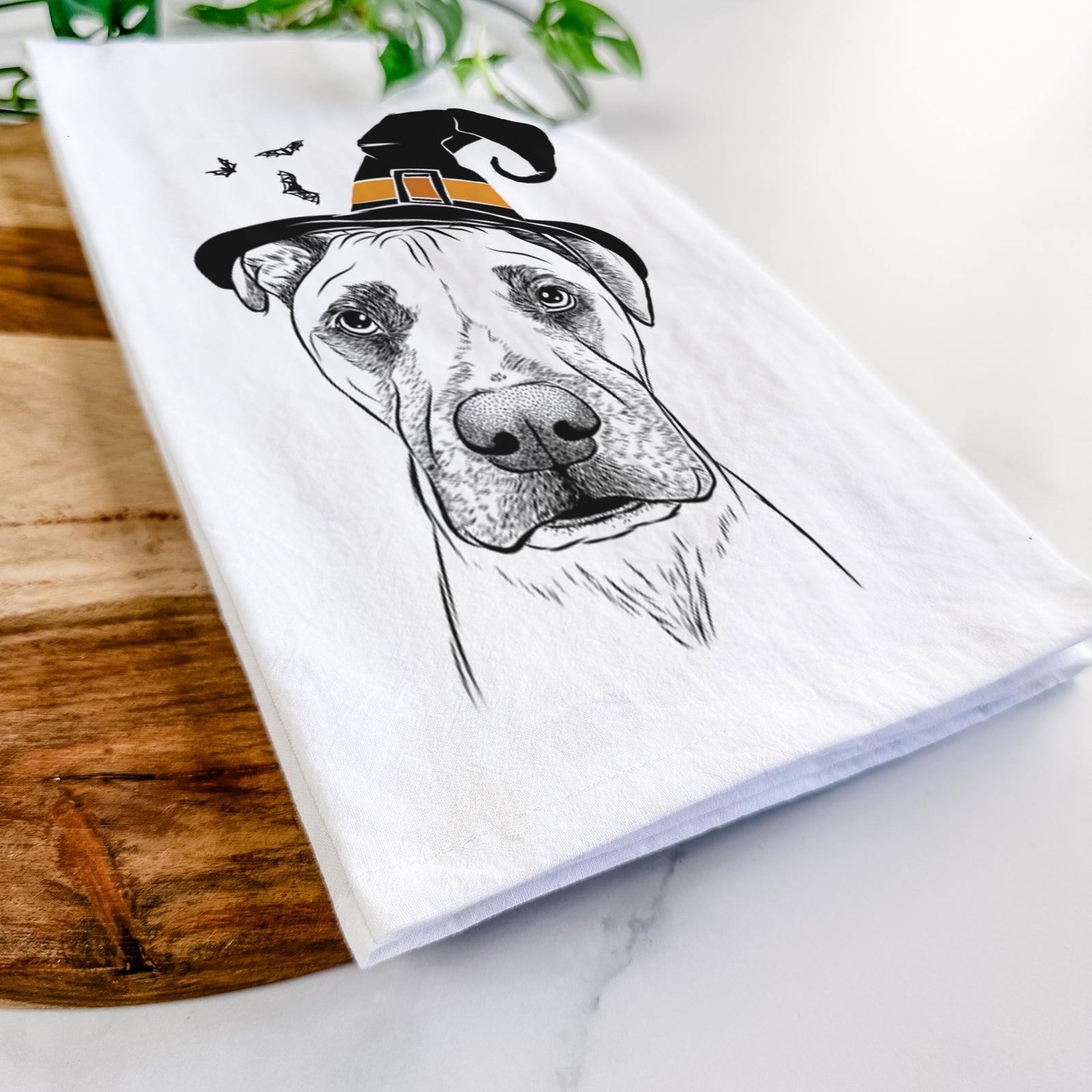 Hand-drawn sketch of Waylon the Boxane wearing a witch hat on a tea towel