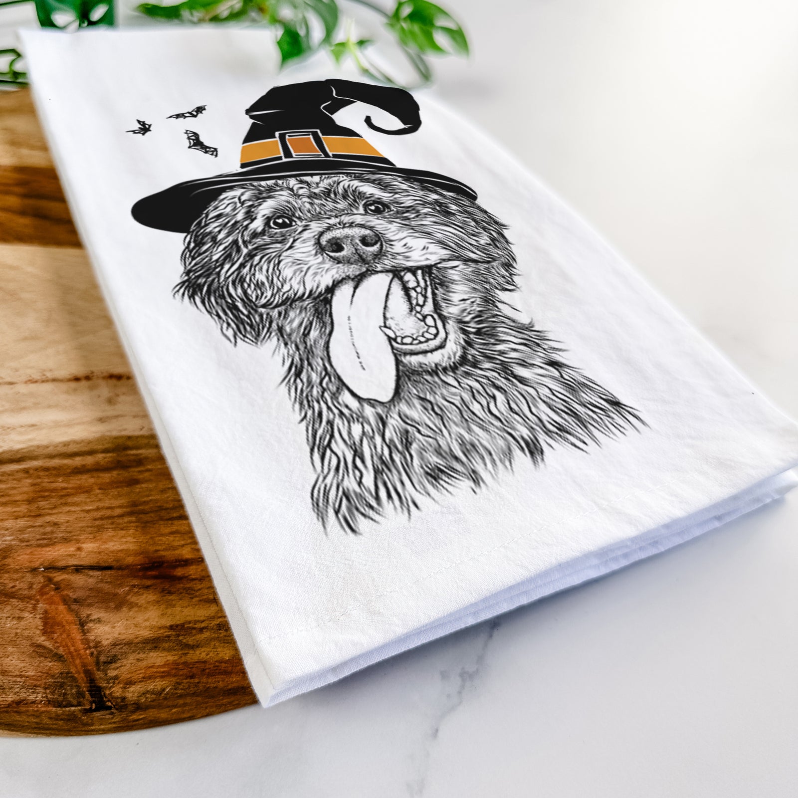 Hand-drawn sketch of Winnie the Mini Aussiedoodle wearing a witch hat on a tea towel