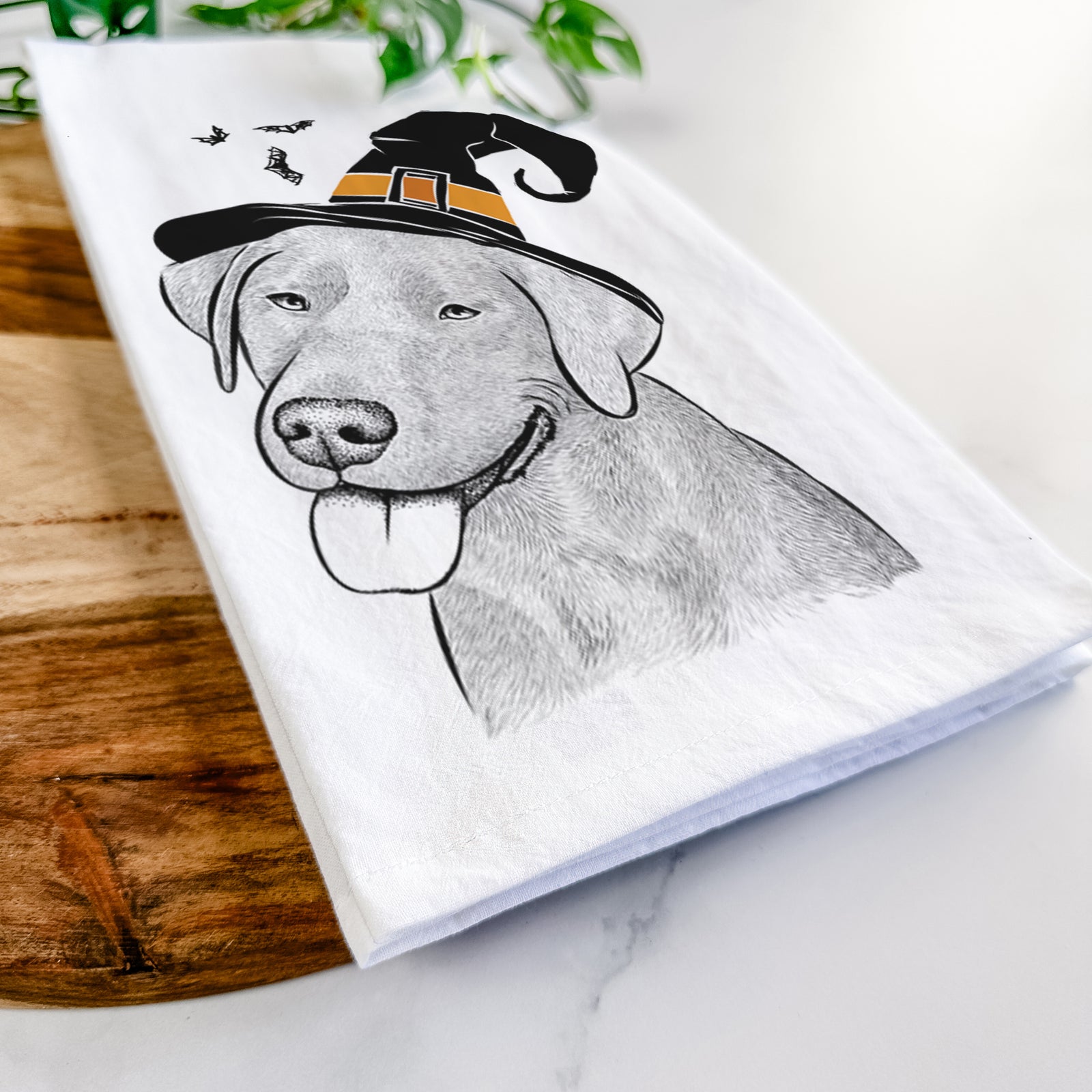 Hand-drawn sketch of Zeppelin the Black Labrador wearing a witch hat on a tea towel